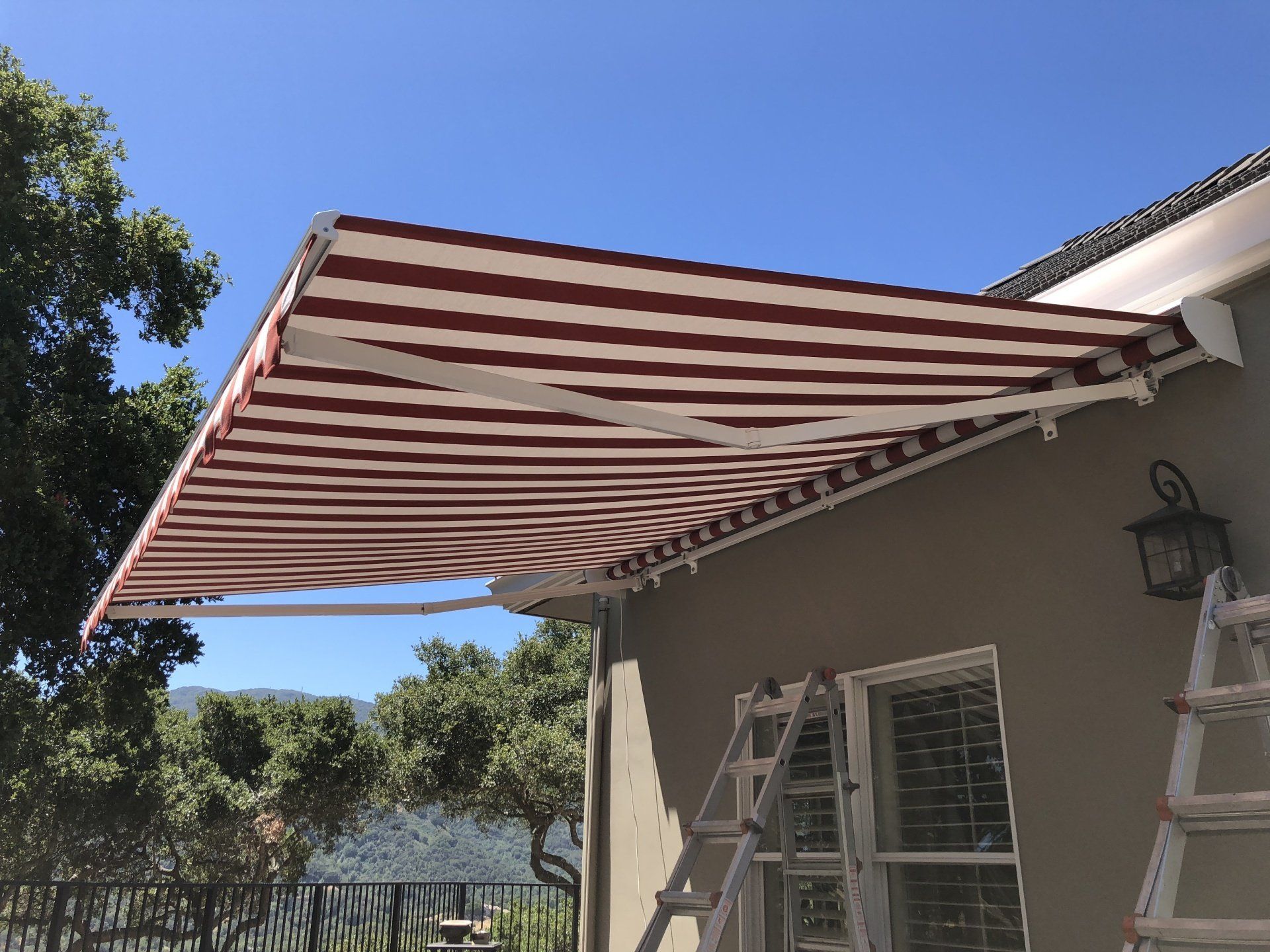 A red and white striped awning is on the side of a house.