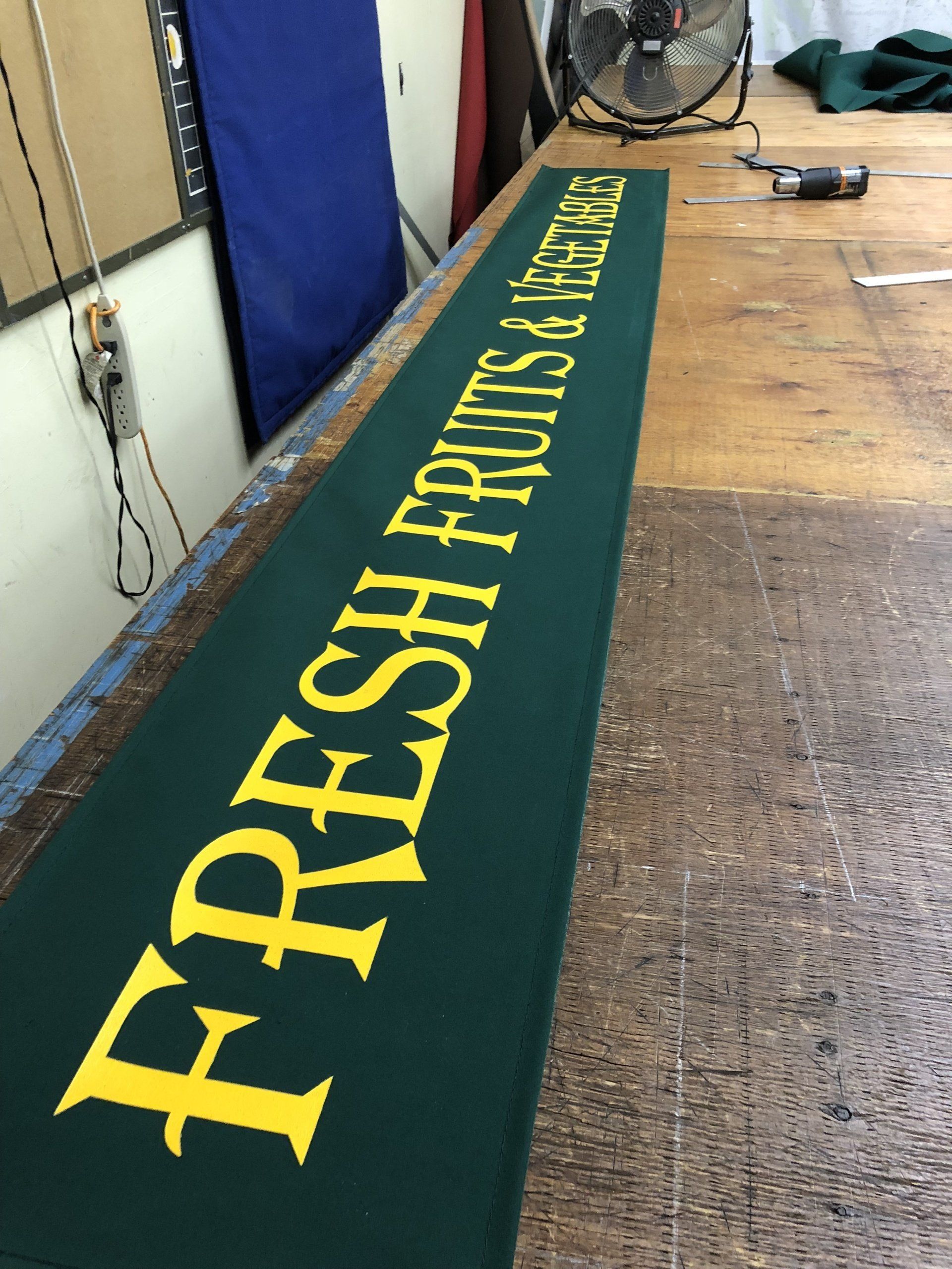 A green sign that says fresh fruits and vegetables