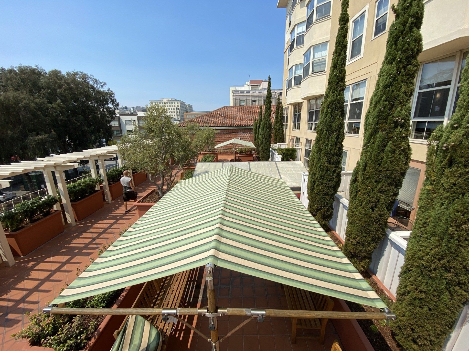 A green and white striped awning is sitting in front of a building