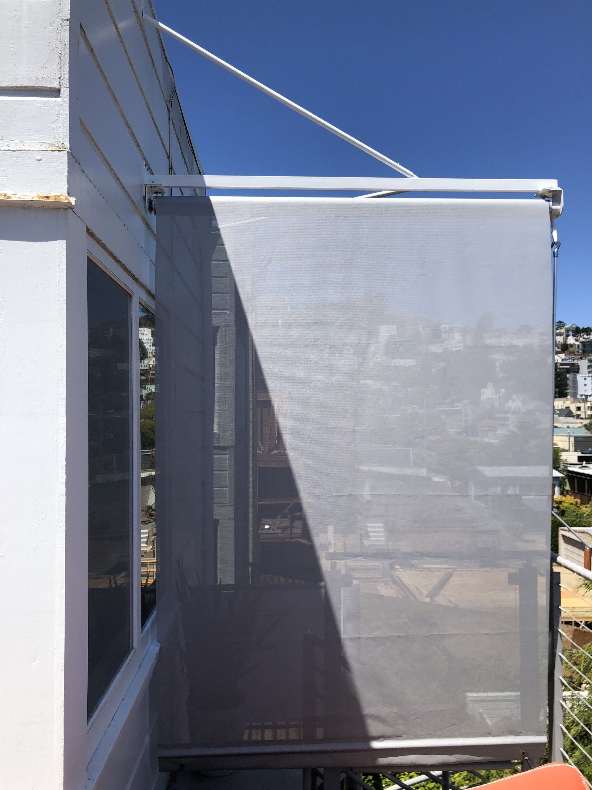A white building with a window and a white screen on the side