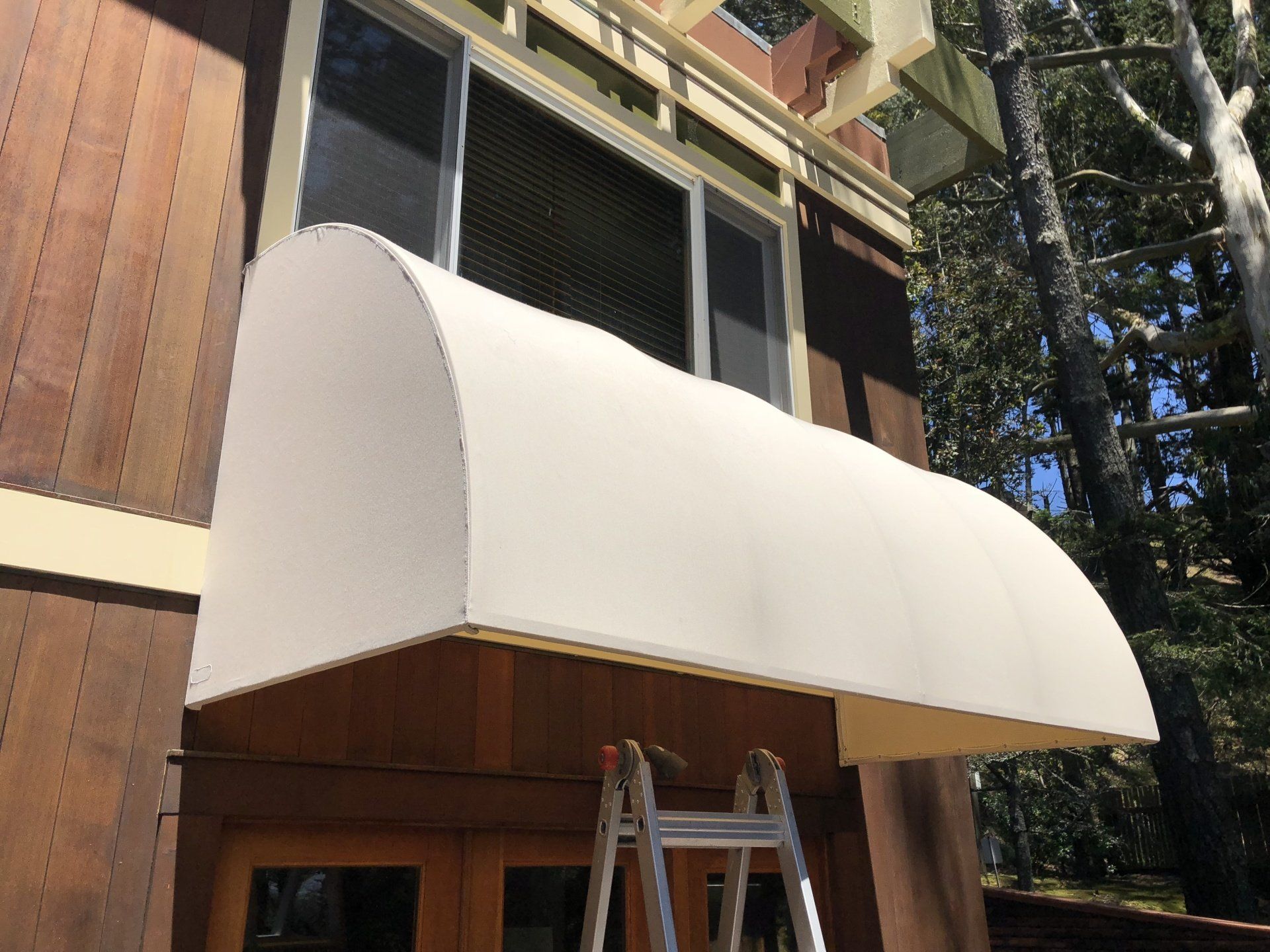 A white awning is on the side of a house