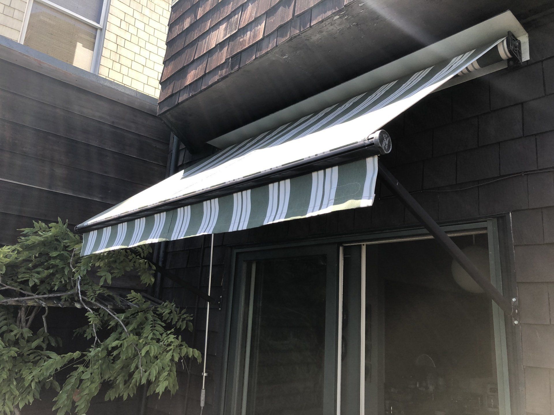 A white and green awning is on the side of a building.