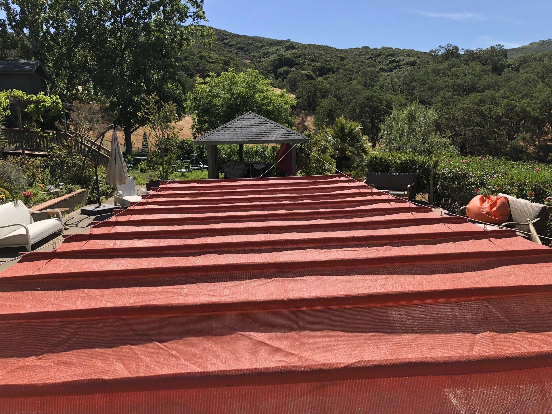 A row of red umbrellas are sitting on top of a lush green field.