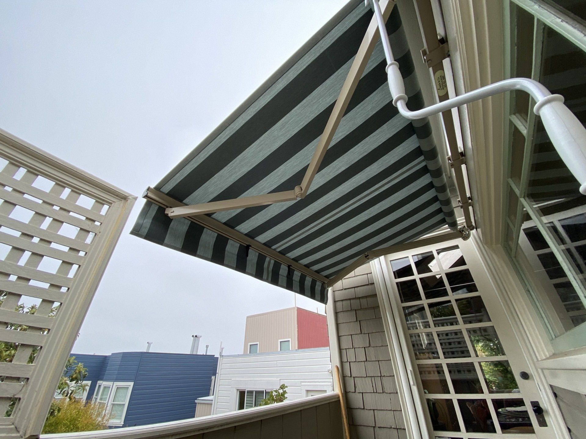 A striped awning is hanging from the side of a building.