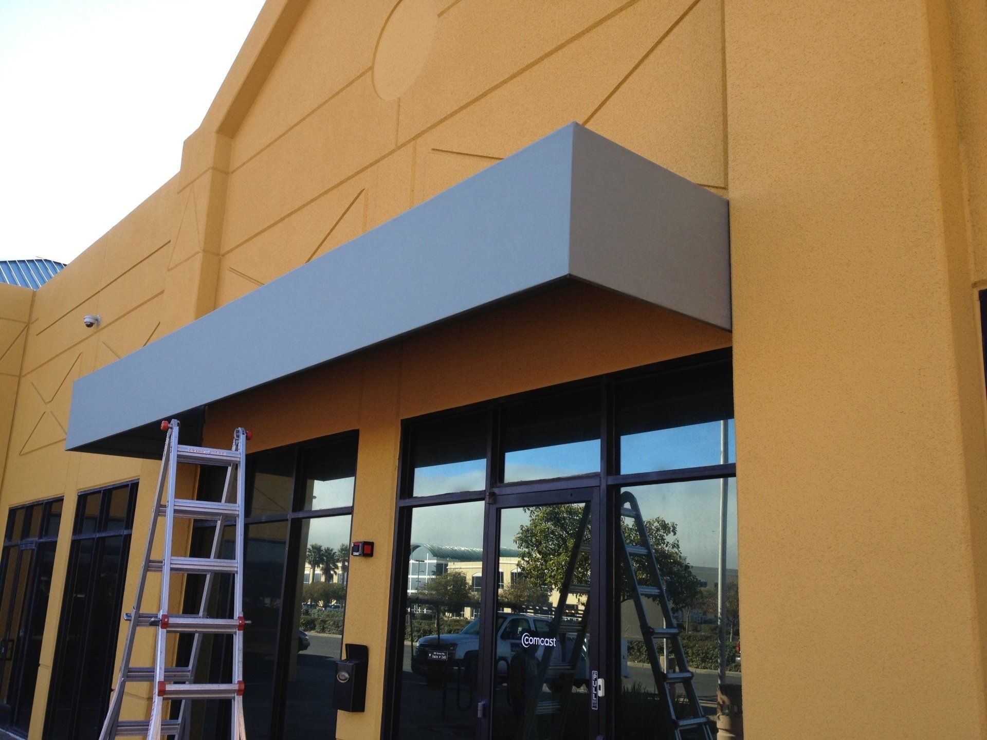 A yellow building with a ladder on the side of it
