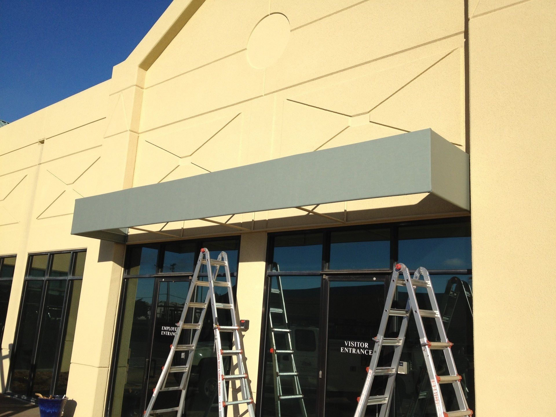 A building with a canopy and ladders in front of it