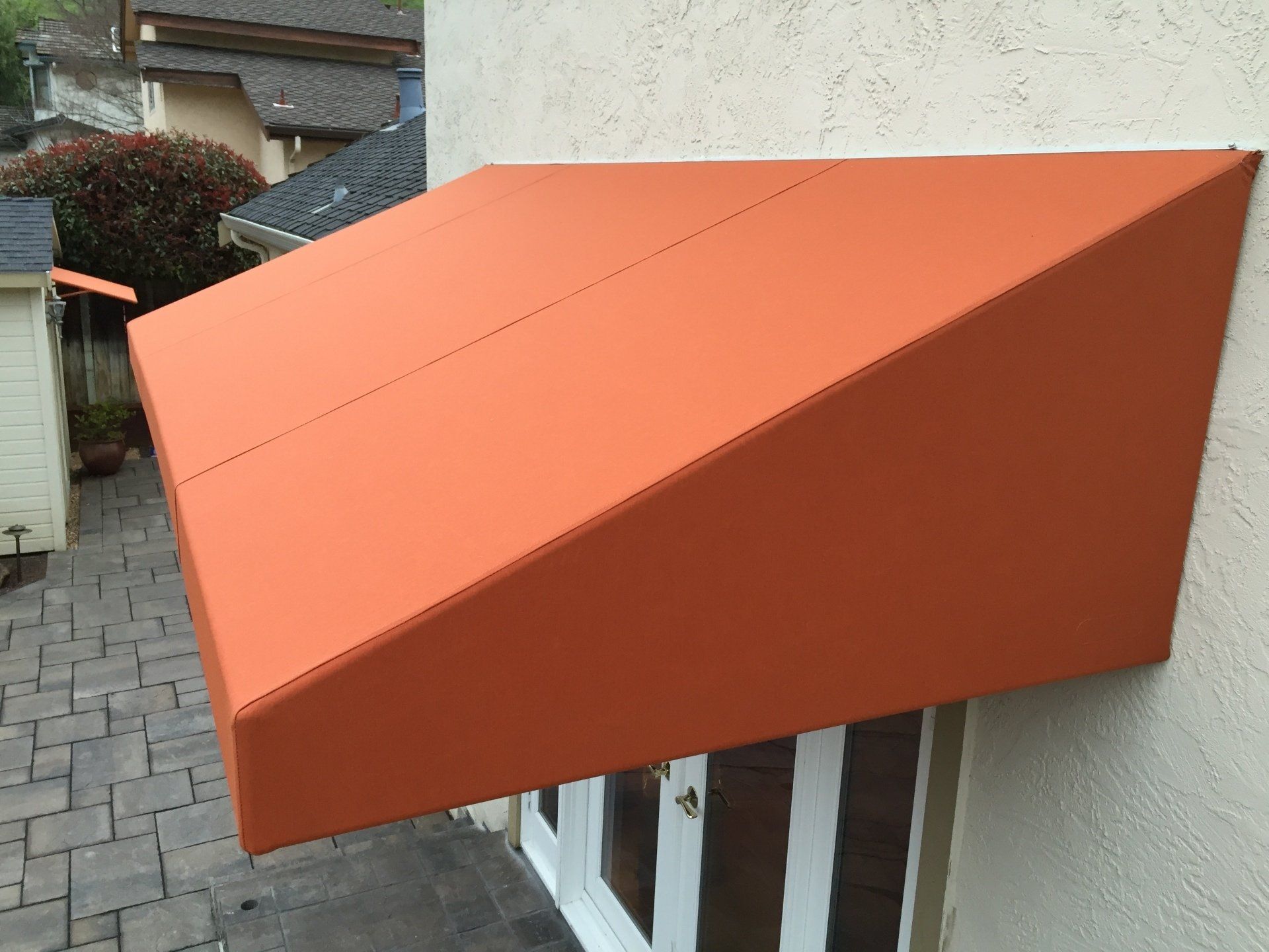 An orange awning is attached to the side of a building.