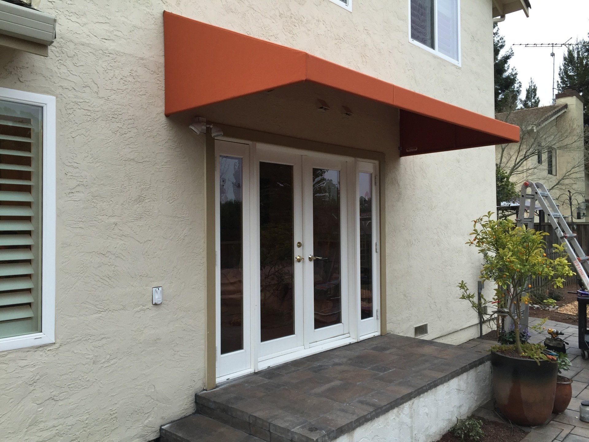 A white house with a red awning over the door