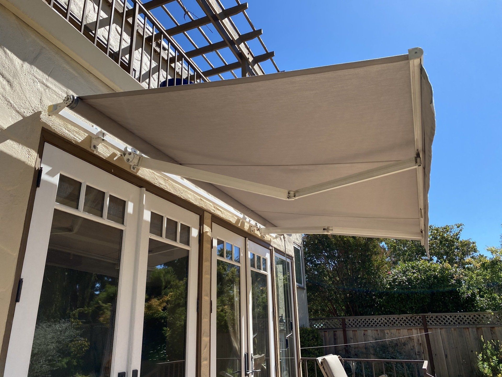 A white awning is hanging over a patio door.