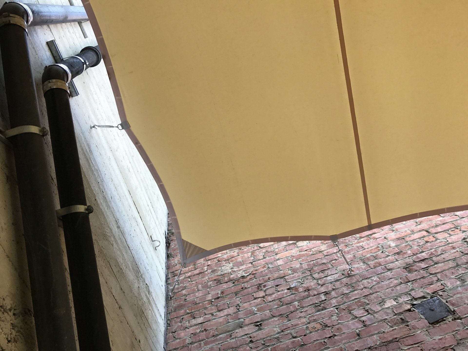 A large umbrella is hanging from the side of a building.