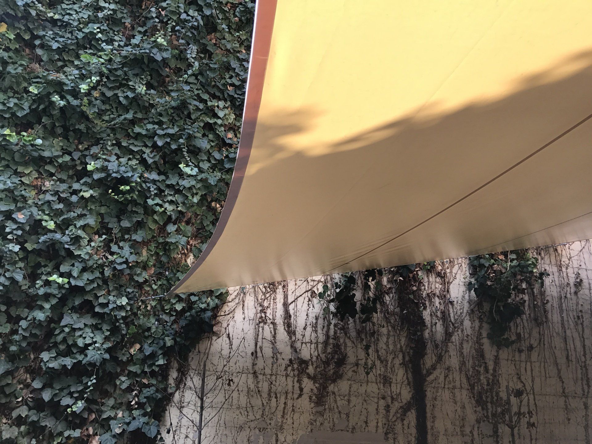 A yellow umbrella is hanging from the ceiling of a building