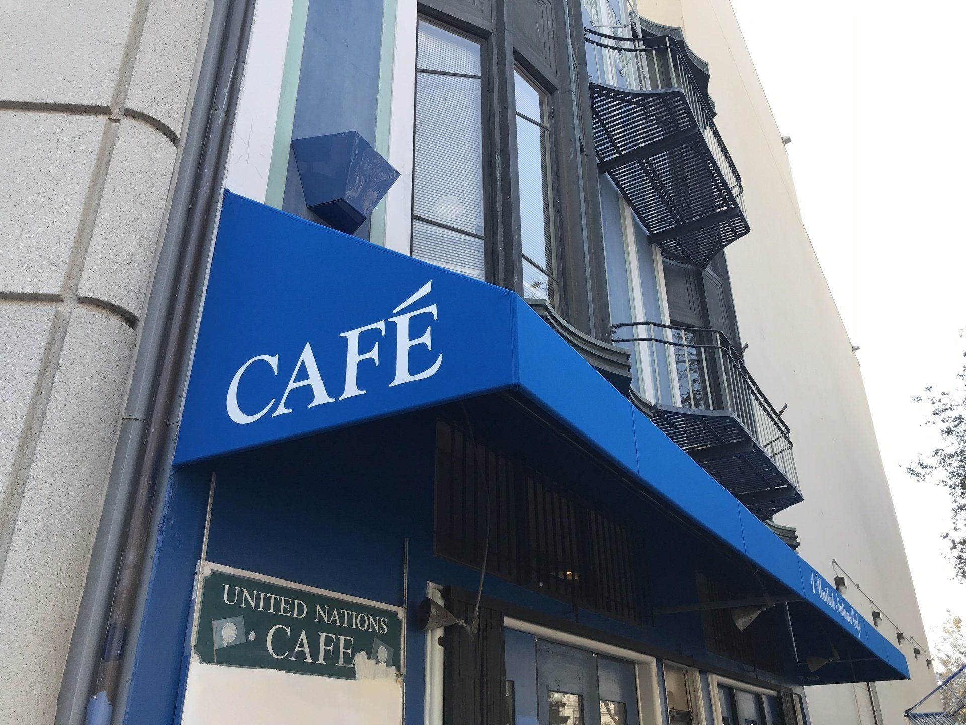 A blue awning with the word cafe on it