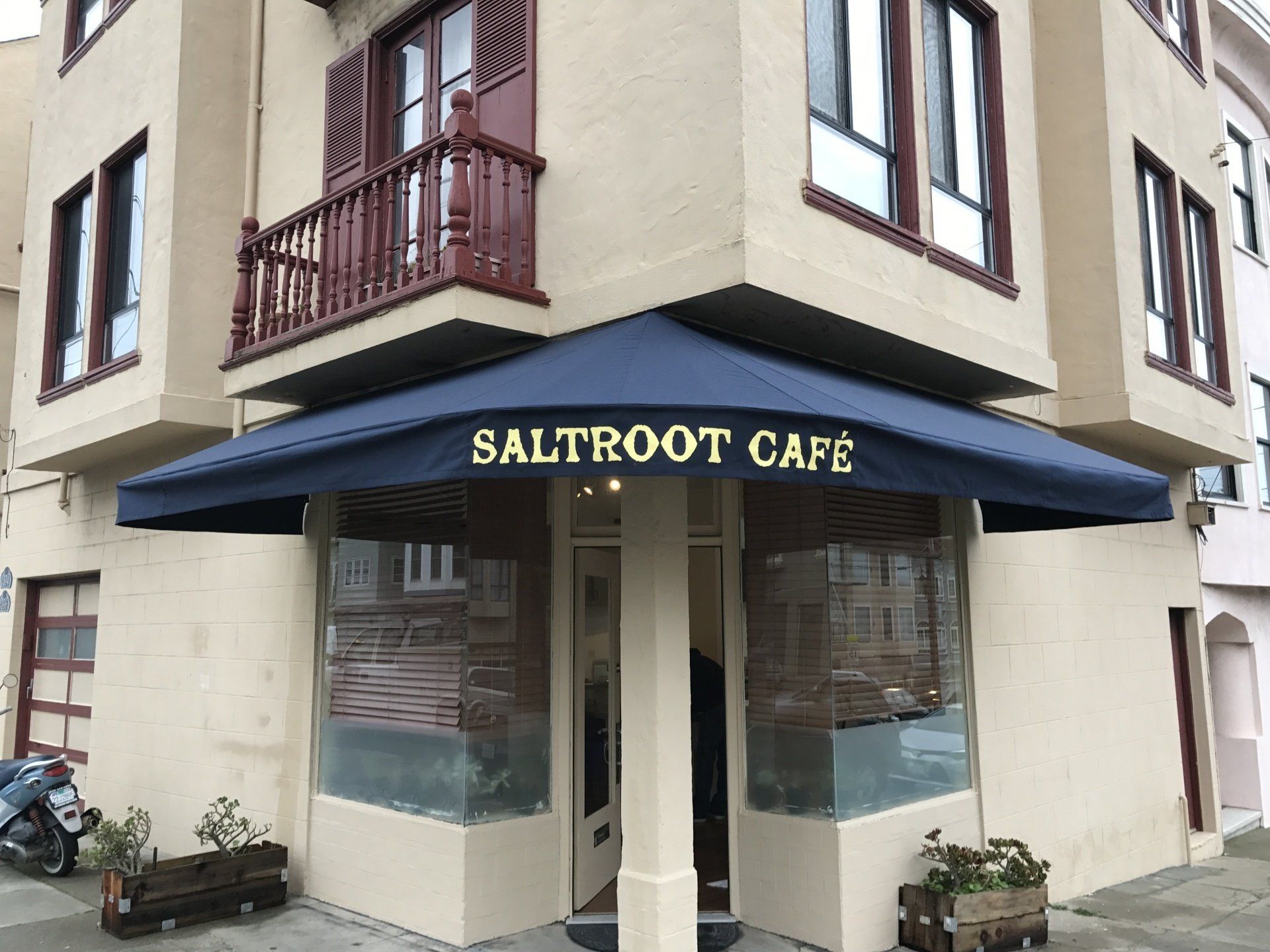 A building with a blue awning that says saltroot cafe