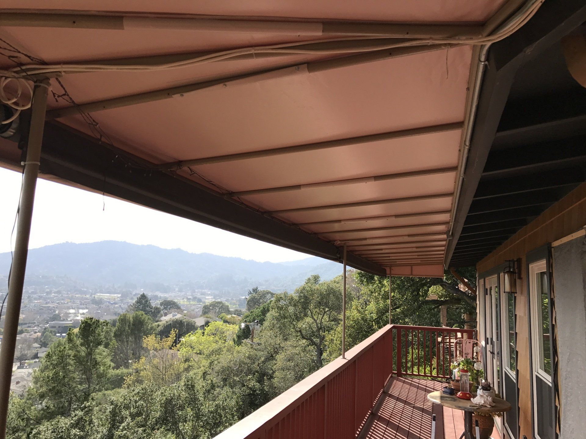 A balcony with a view of the mountains and trees.