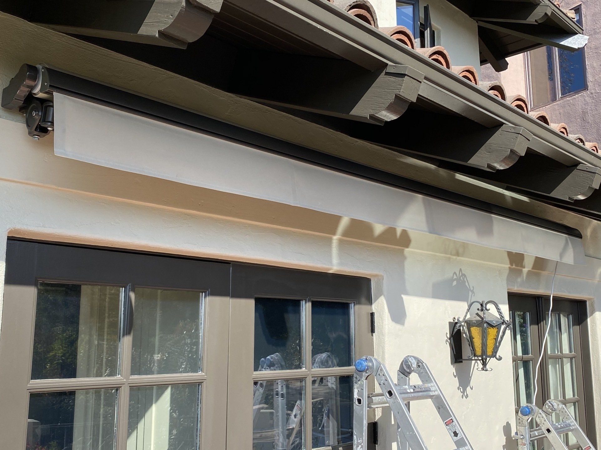 A ladder is sitting on the side of a building next to a window.