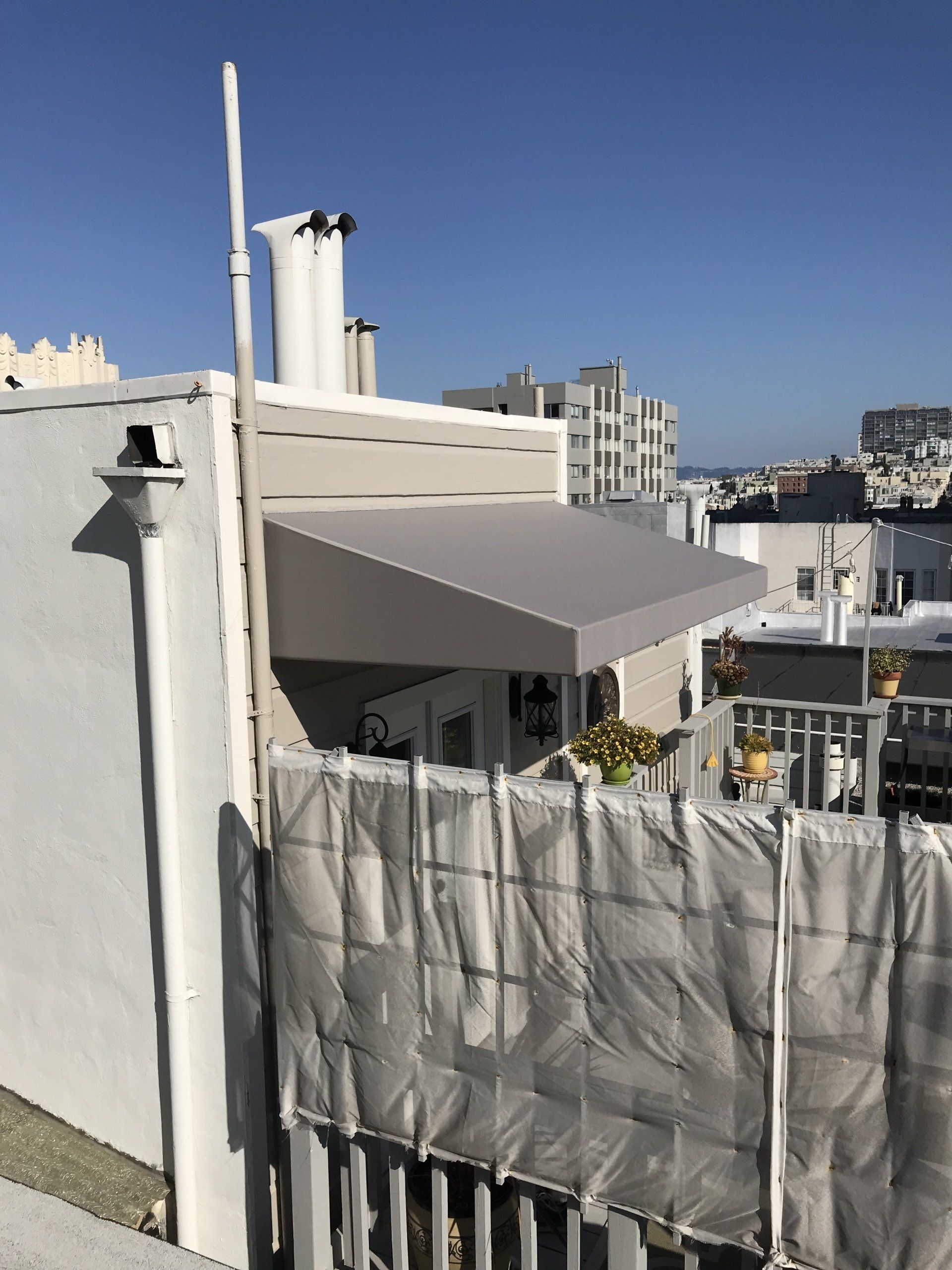 A white building with a white awning on top of it