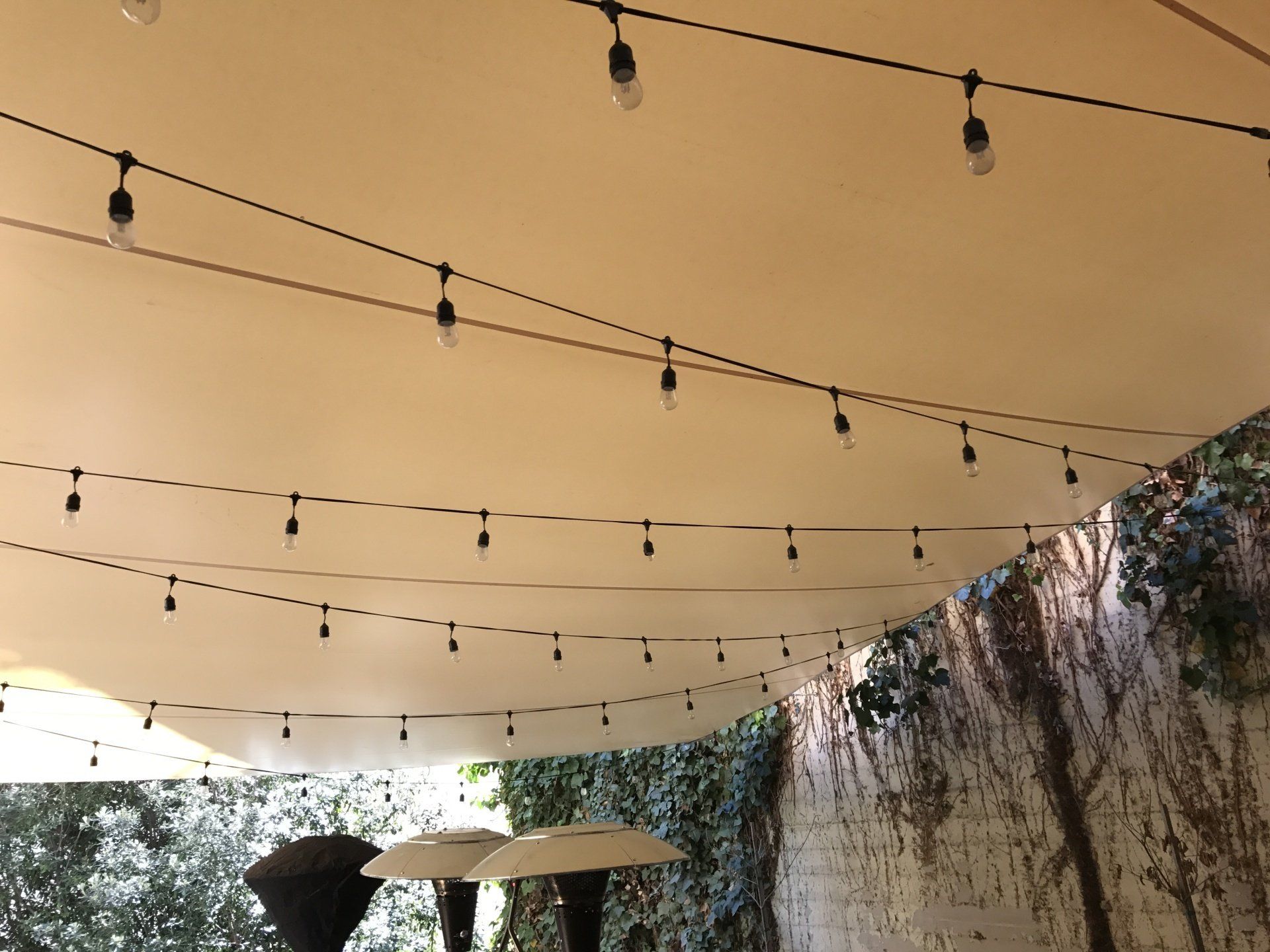 A string of lights is hanging from the ceiling of a tent.