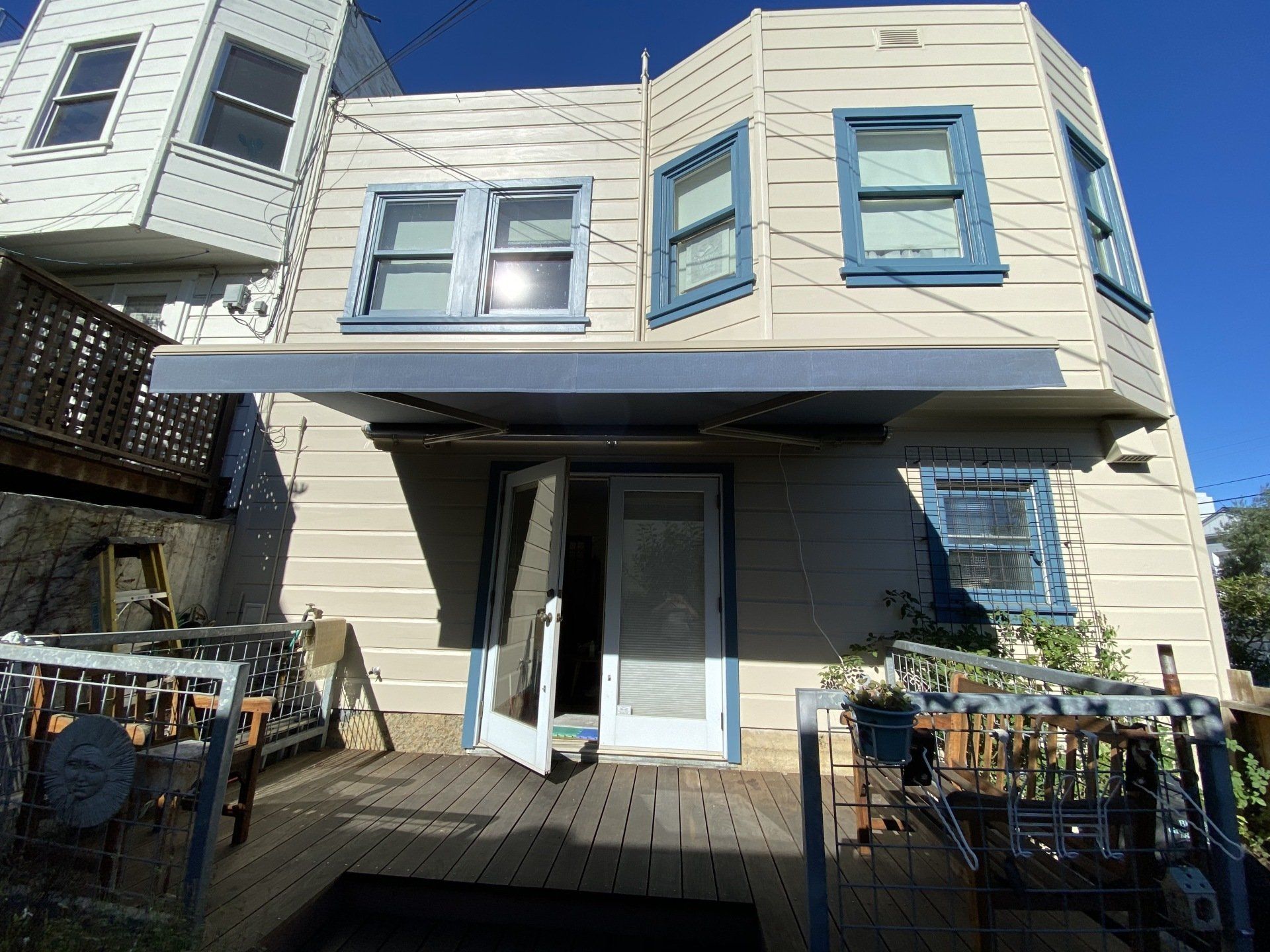 The back of a house with a balcony and awning