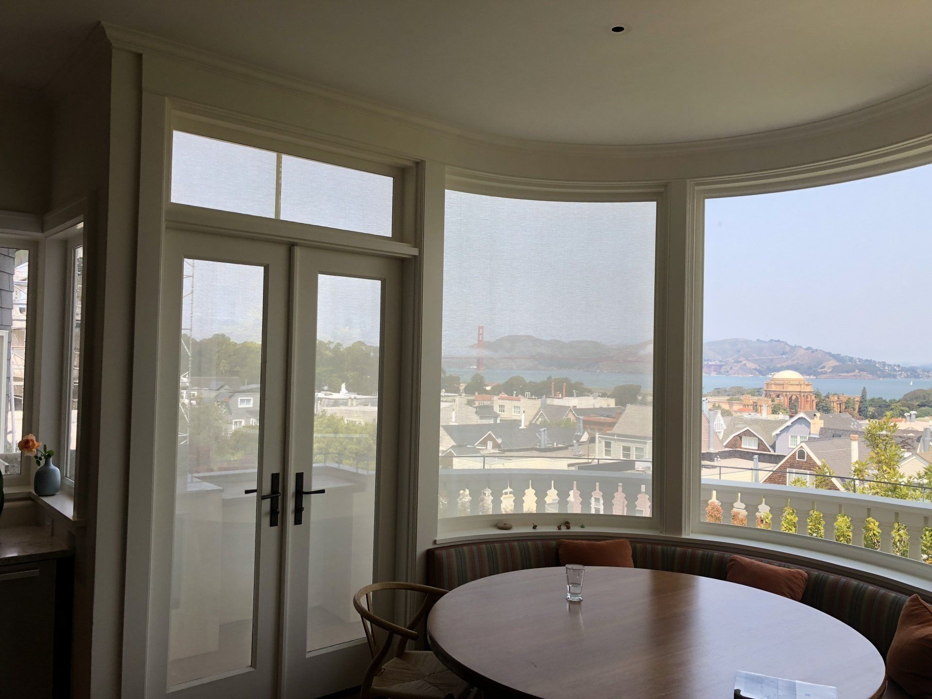 A dining room with a table and chairs and a view of the bay.