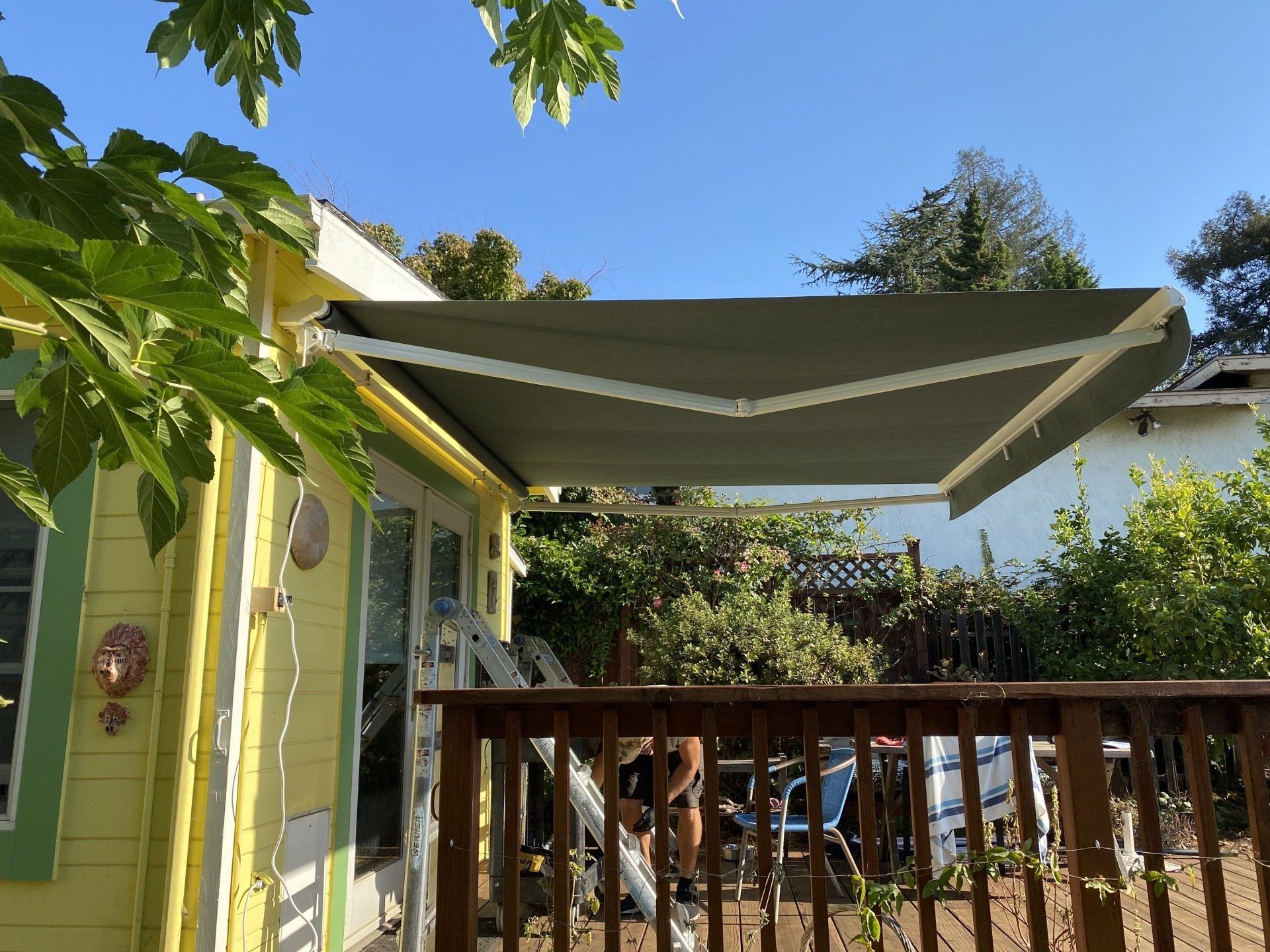 A yellow house with a green awning on the side of it