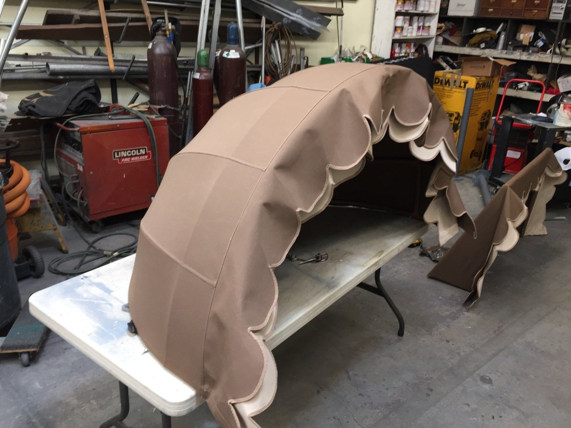 A large umbrella is sitting on top of a white folding table.