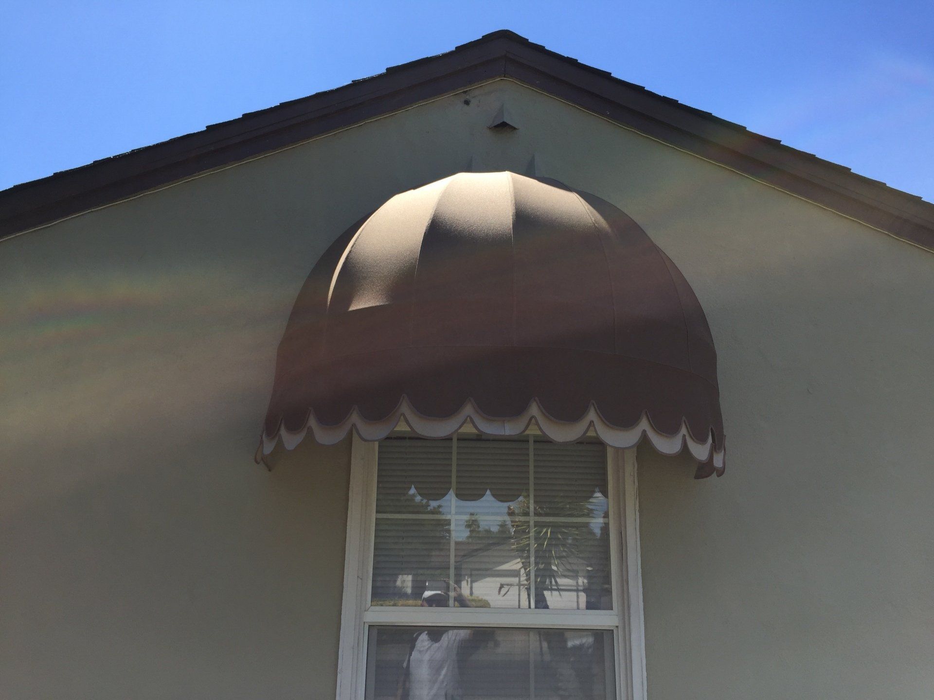 A window with a brown awning over it