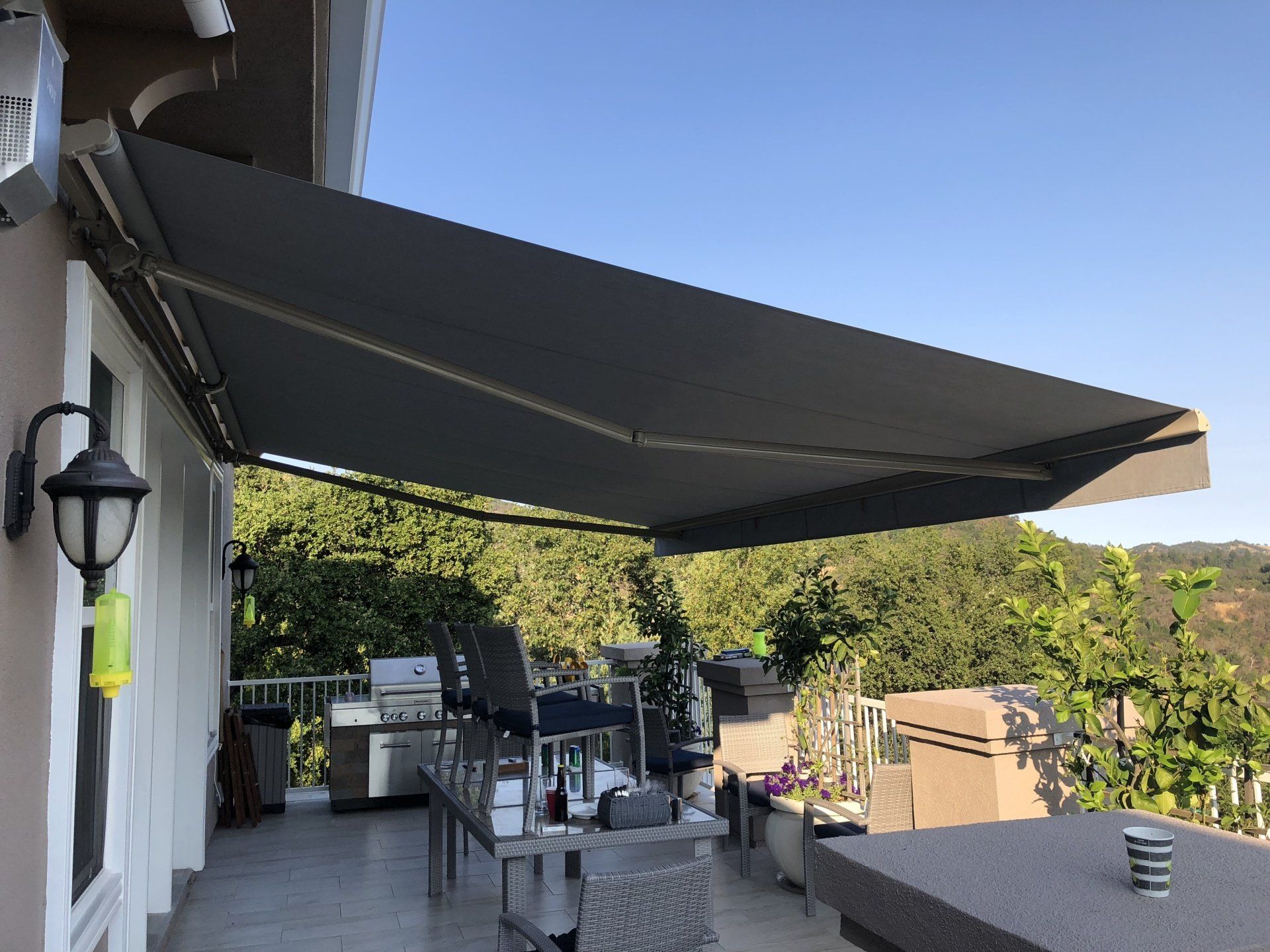 A large awning is covering a patio with a view of the mountains.