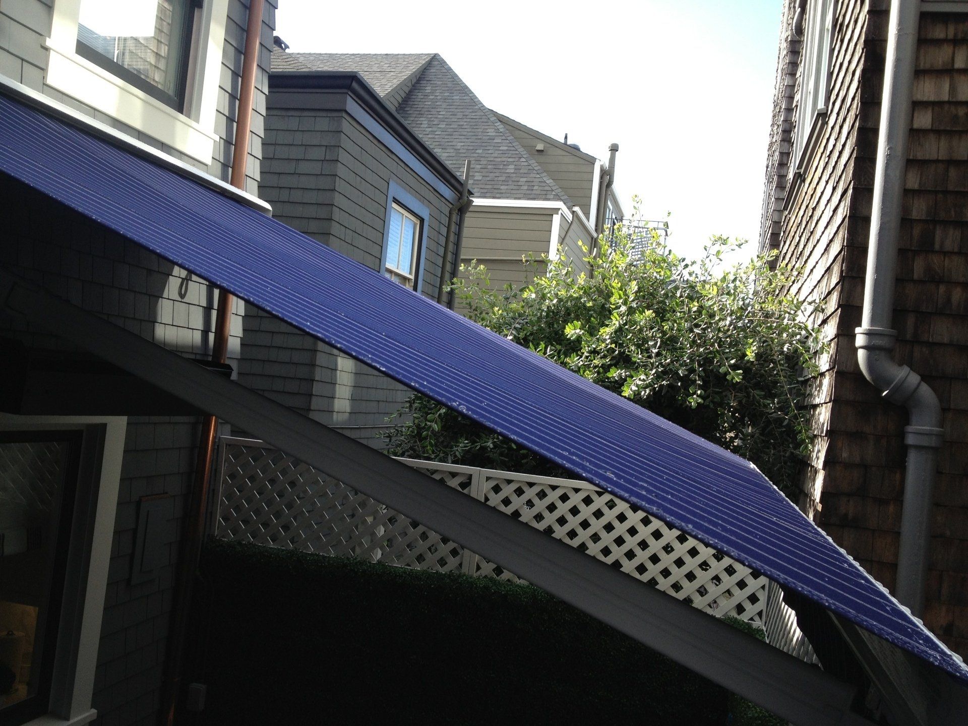 A blue tarp is hanging from the side of a building