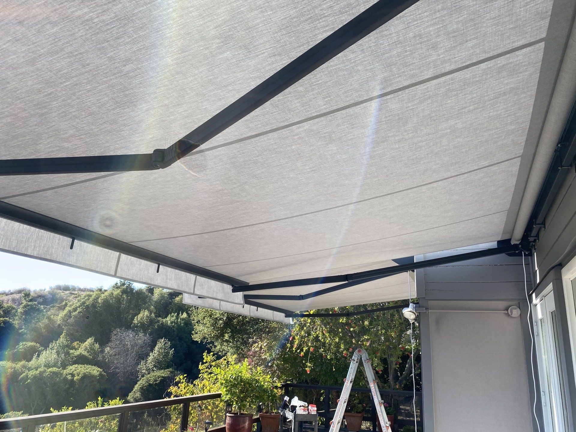 A white awning is being installed on the side of a building.