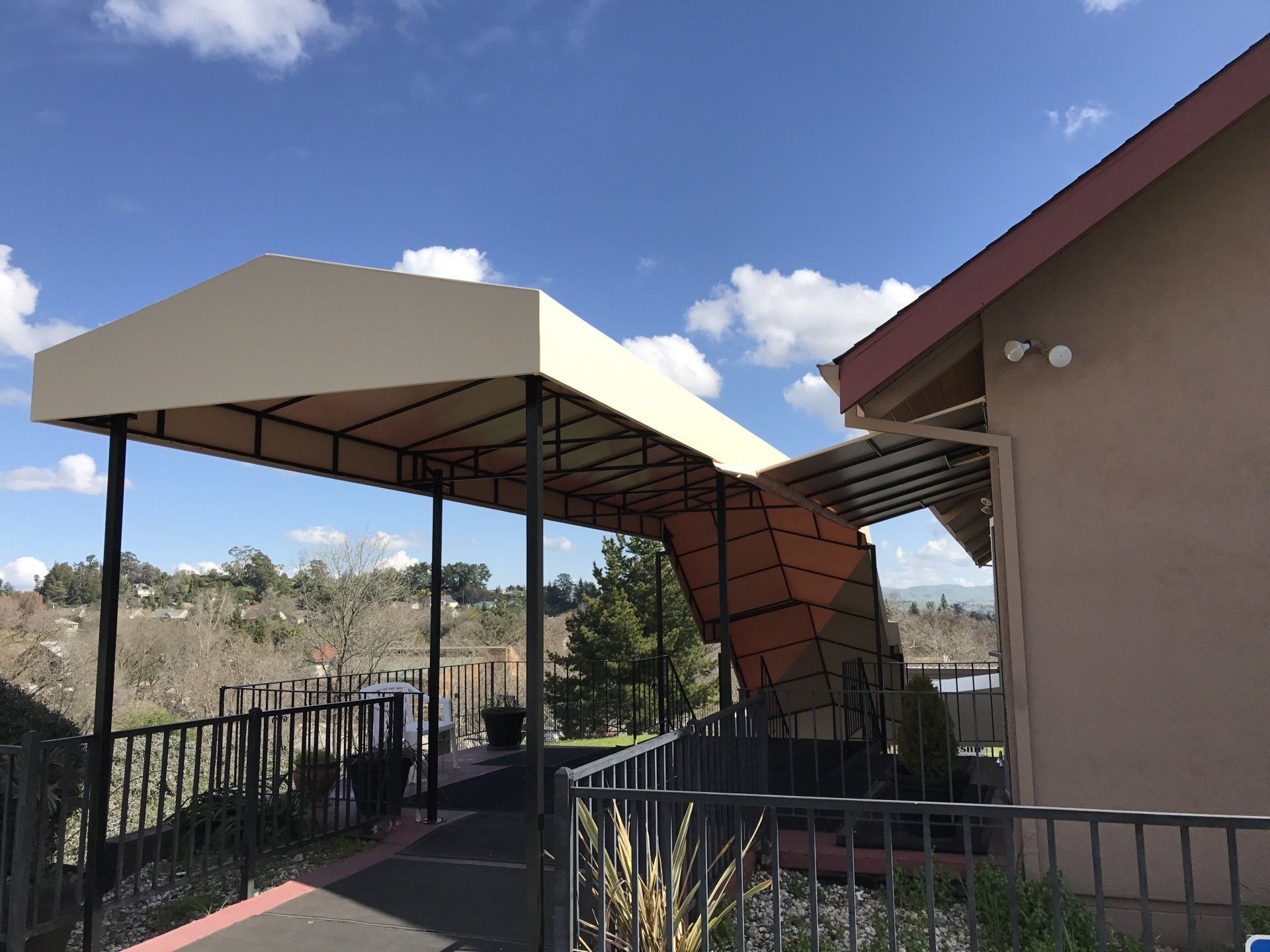 A canopy is sitting on the side of a building next to a staircase.