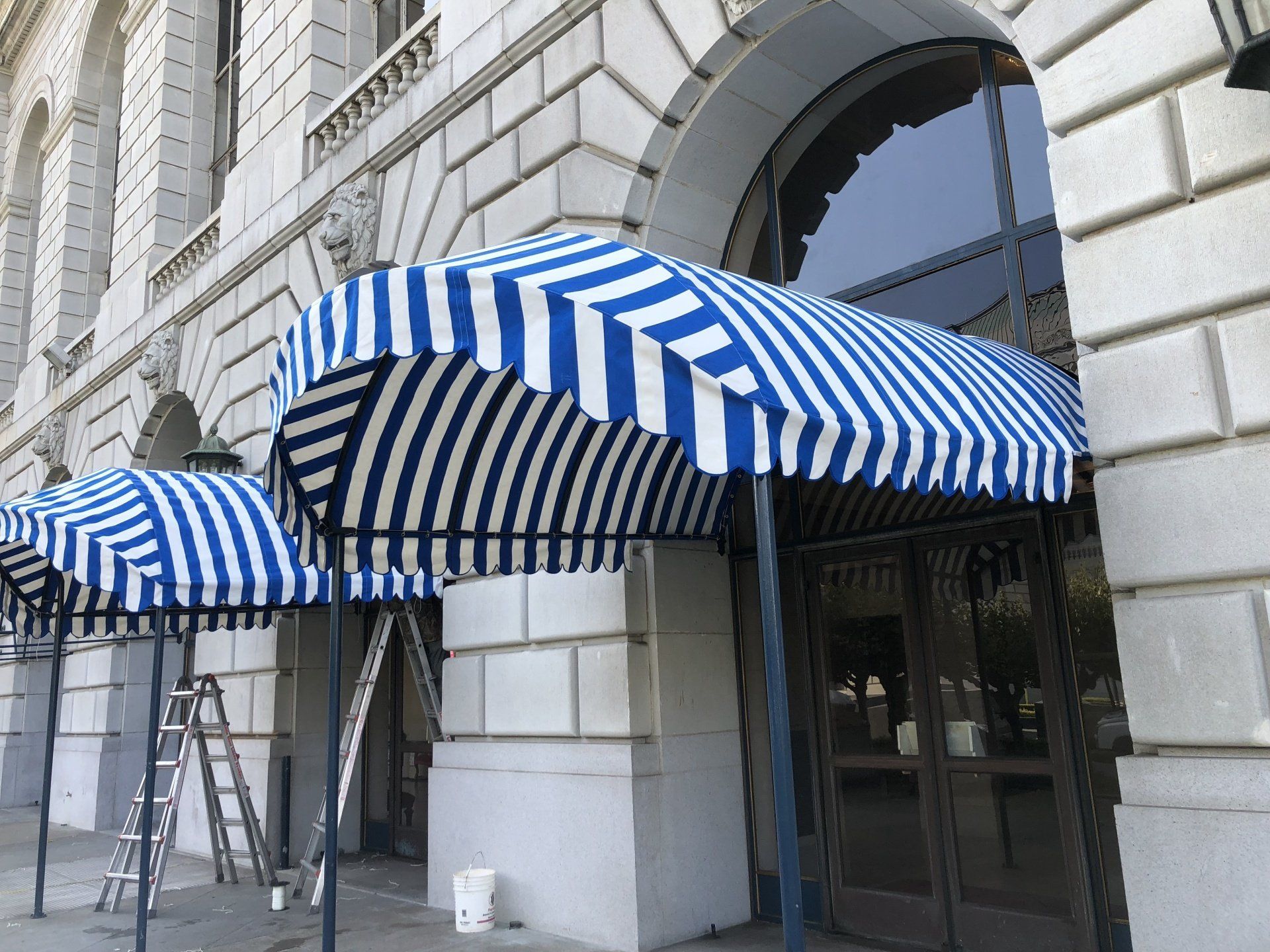 A building with a blue and white striped awning over the entrance
