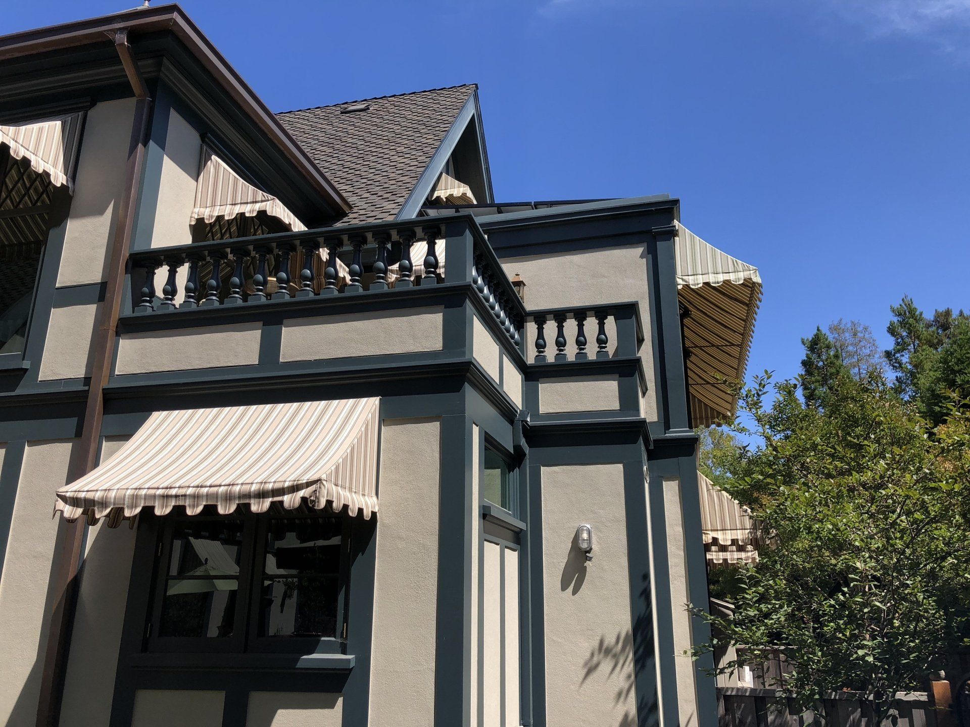 A house with a balcony and awnings on it