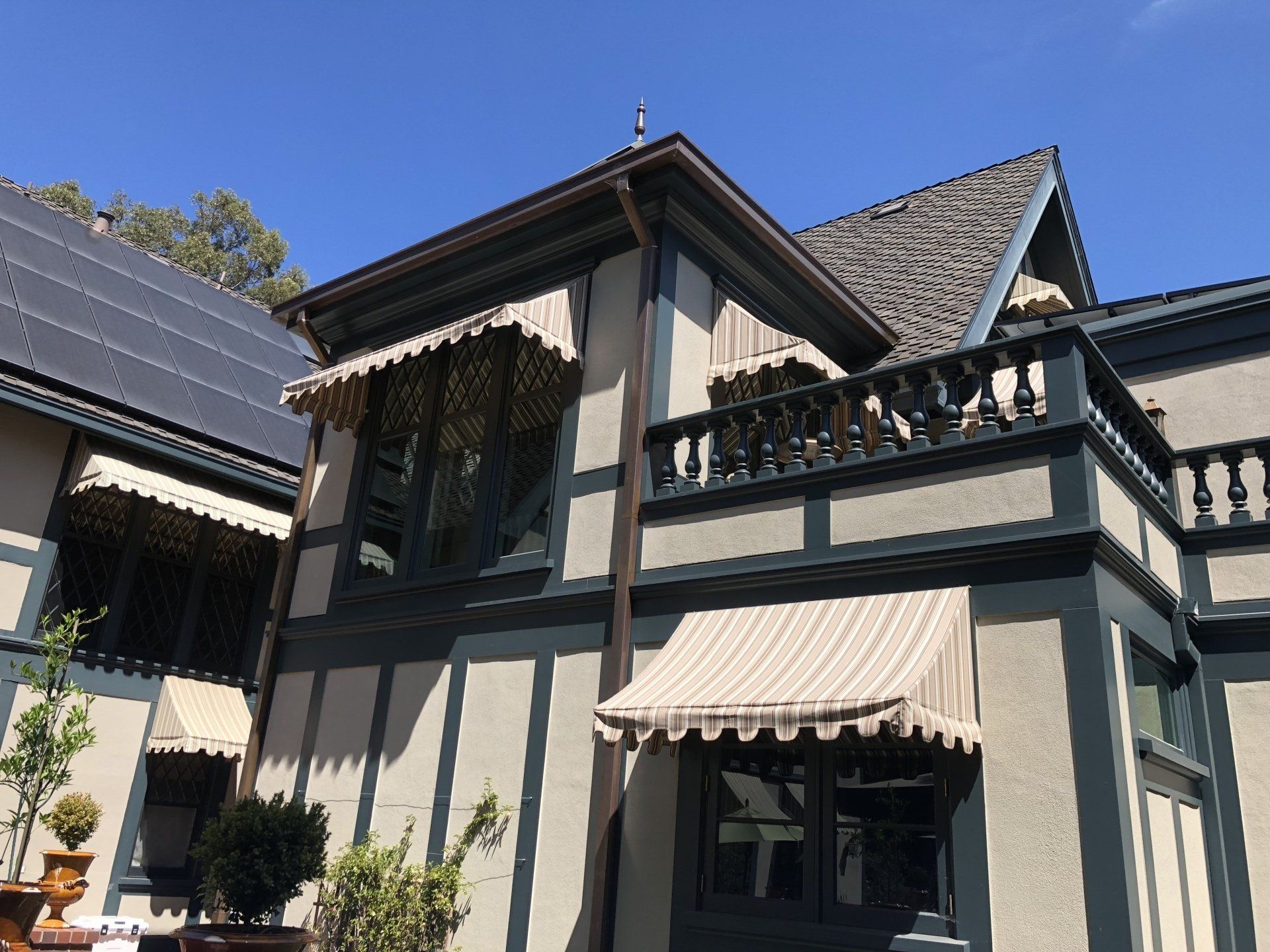 A large house with a balcony and awnings on the windows