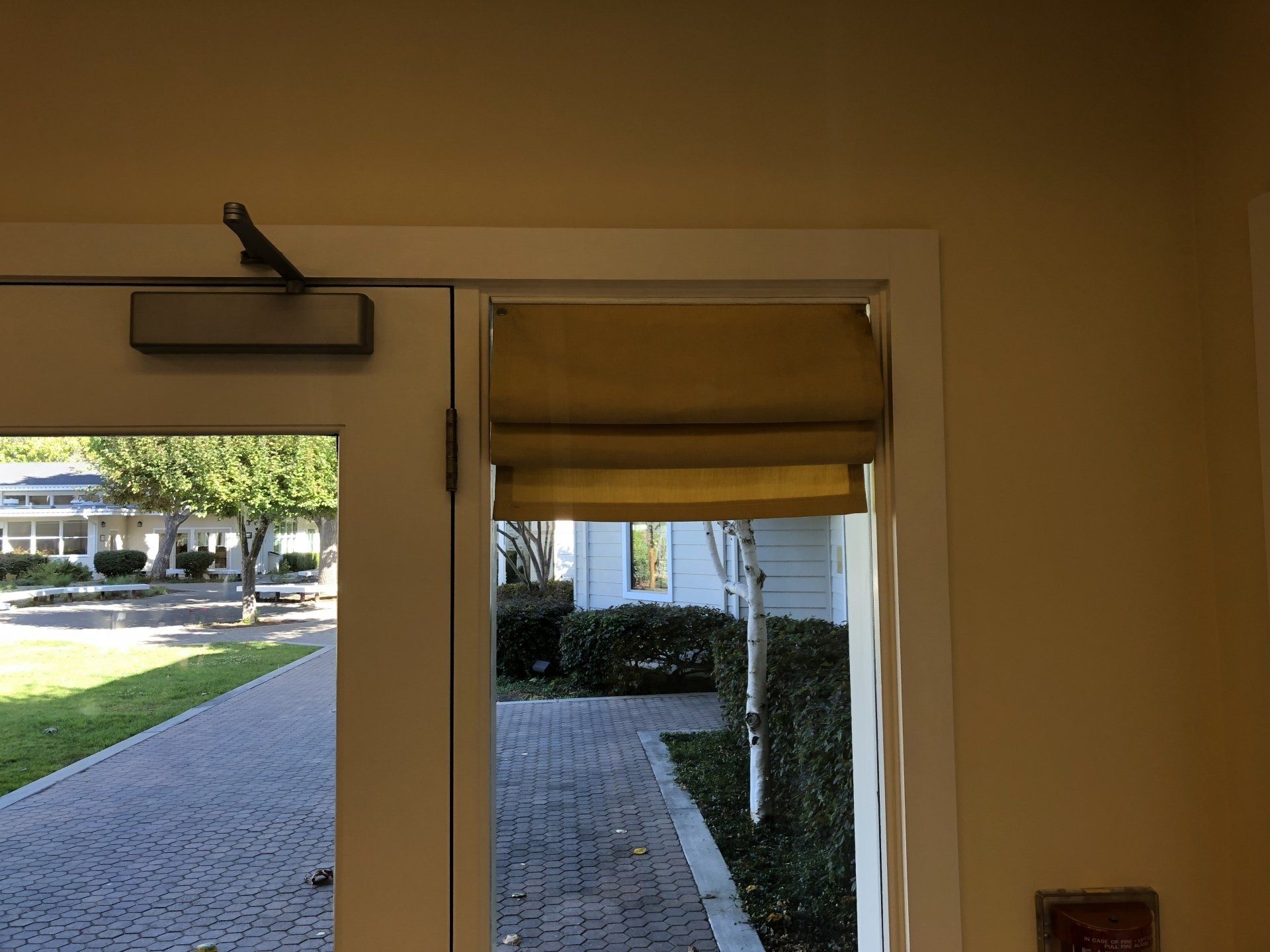 A door with a blind on it and a view of a house