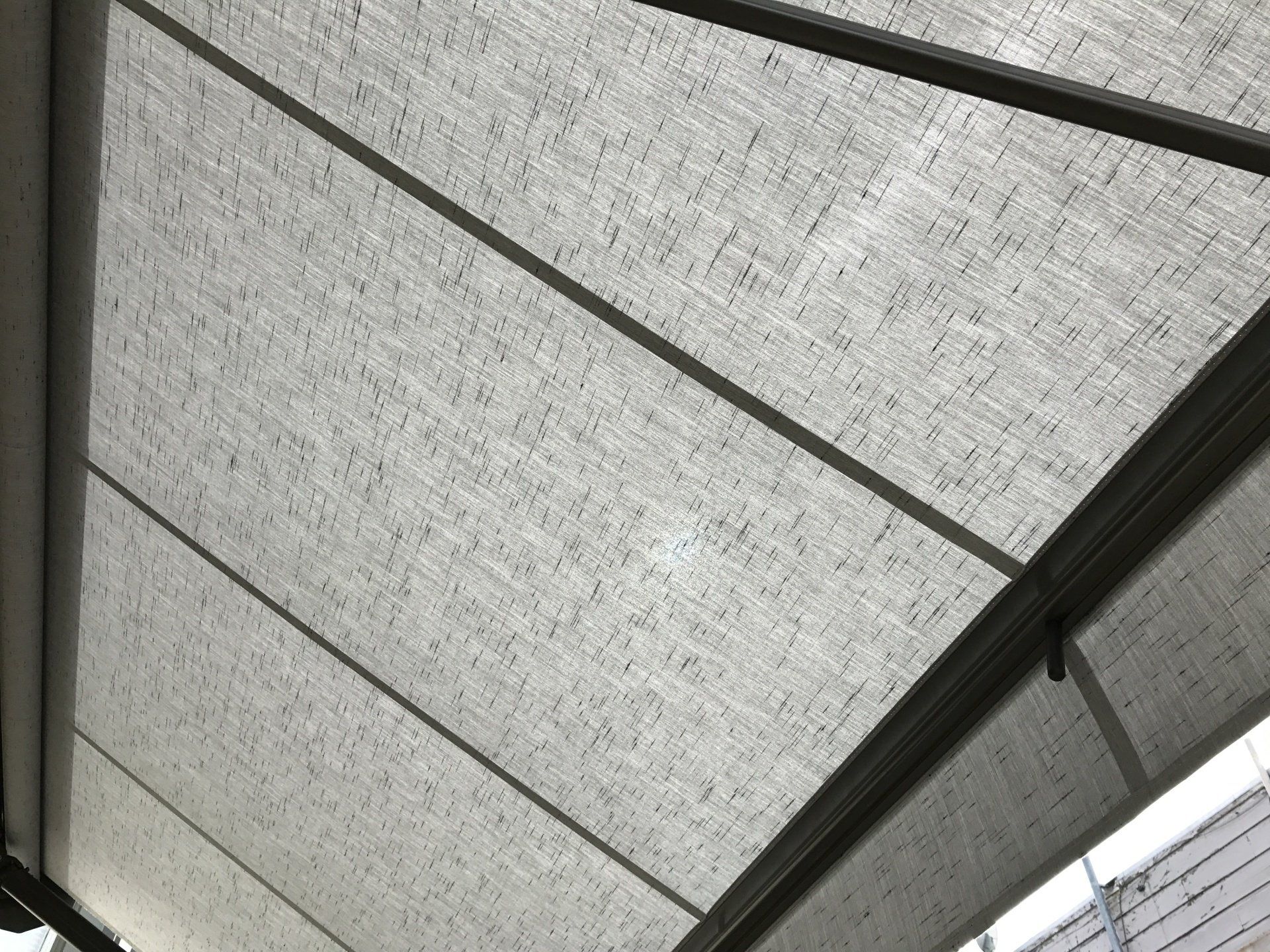 A close up of a white awning with a black frame.