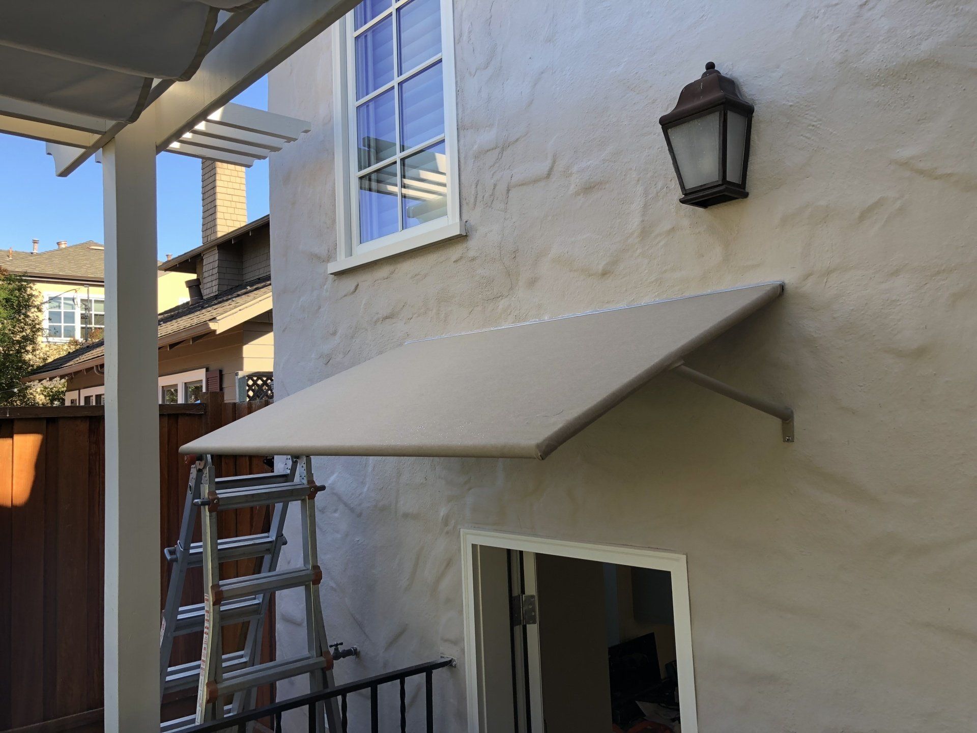 A white house with a window and a canopy over it