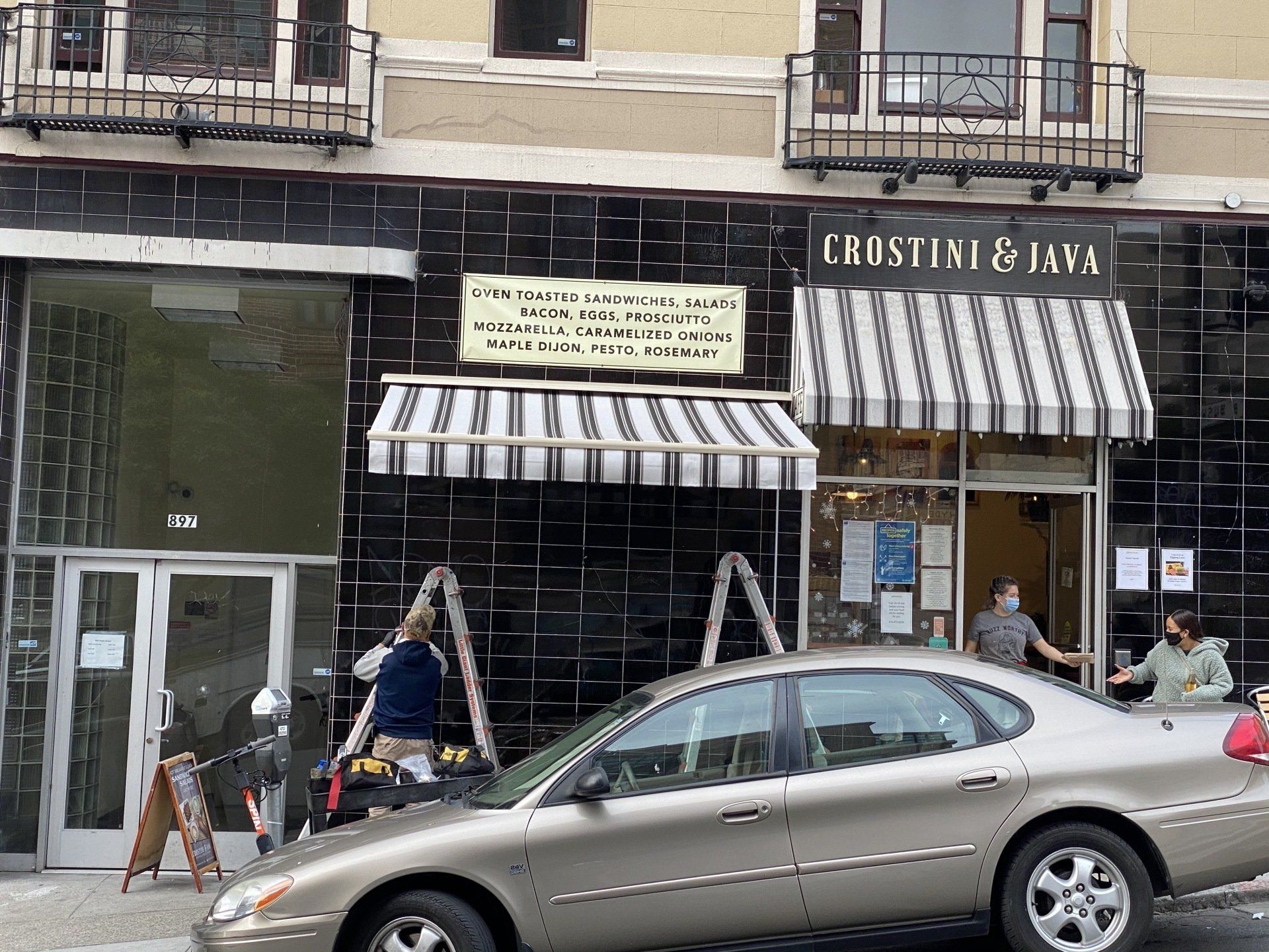A car is parked in front of a store called christine & java