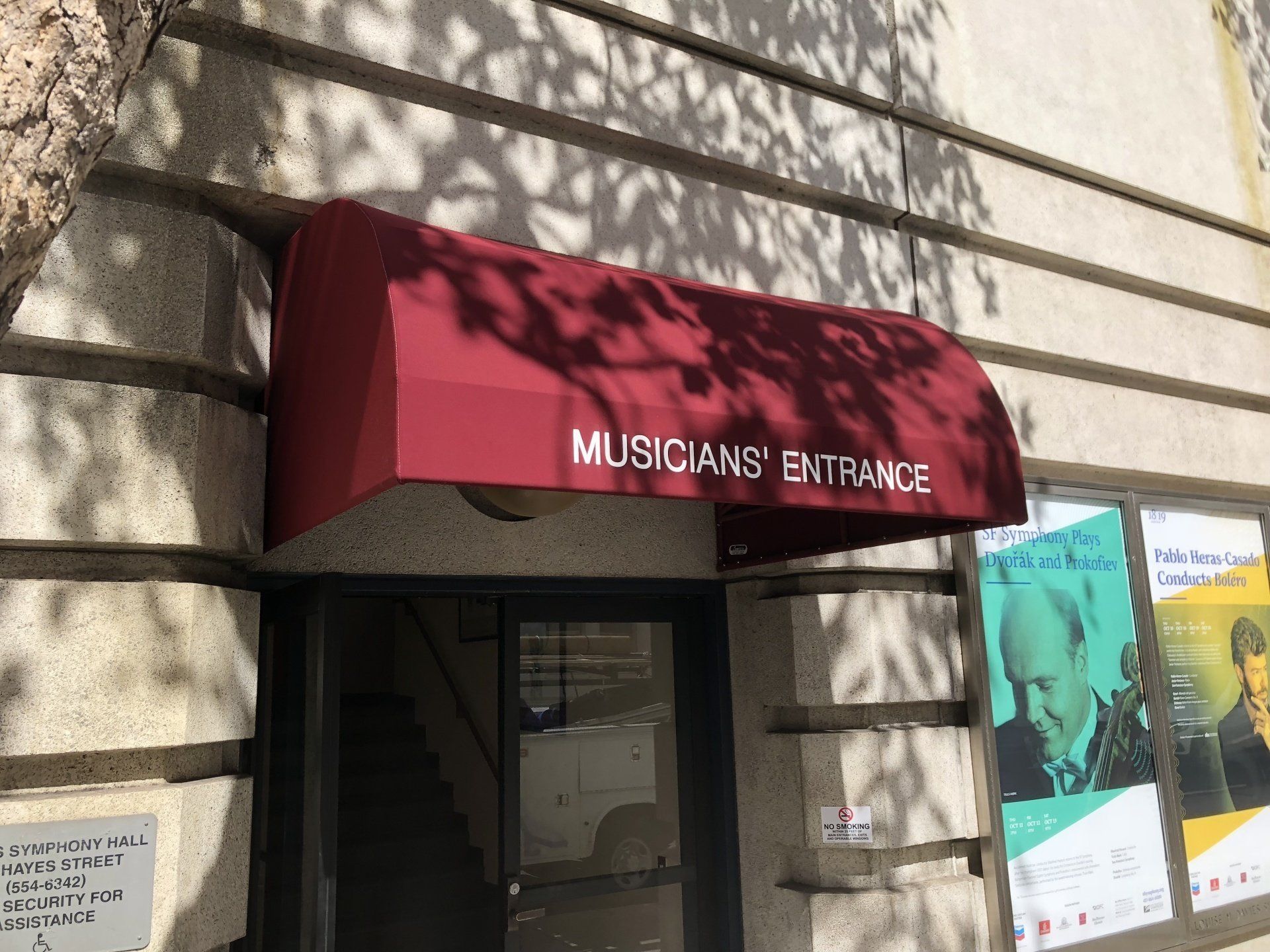 A red awning over the entrance to musicians ' entrance