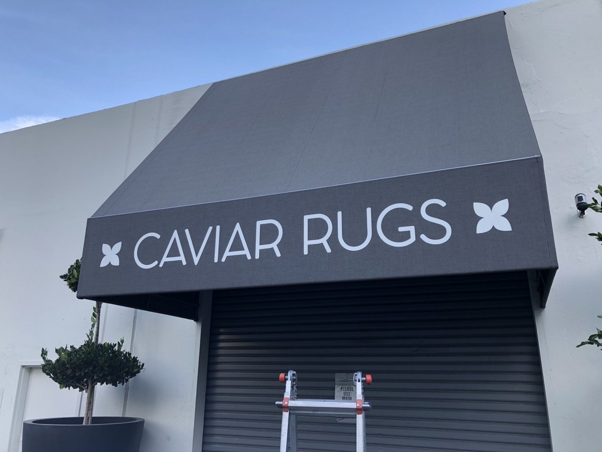 A black awning with the words caviar rugs on it