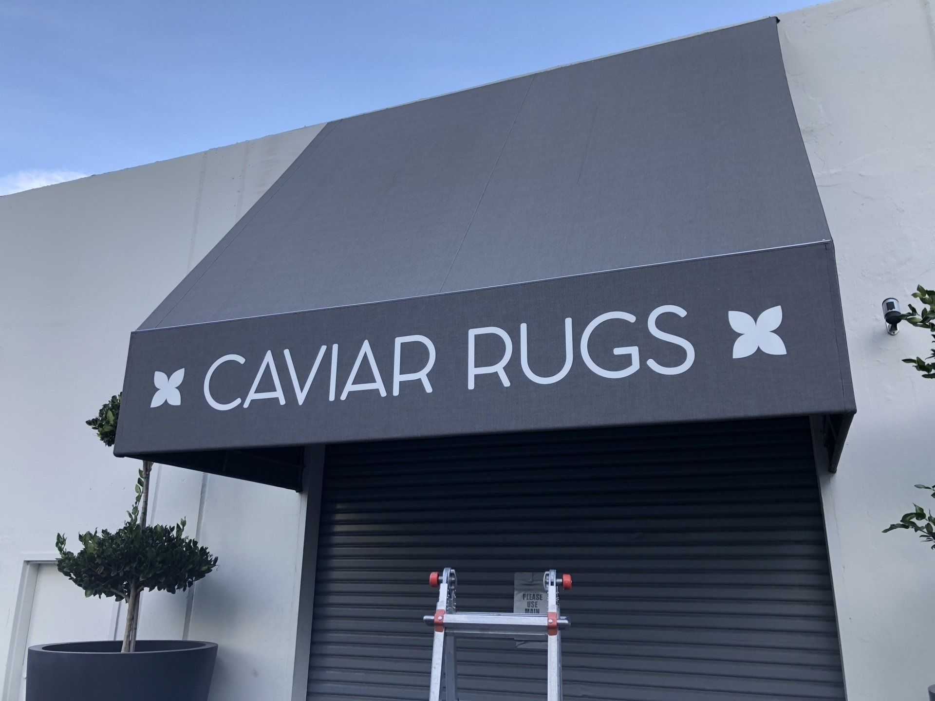 A black awning with the words caviar rugs on it