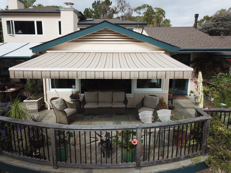An aerial view of a house with a patio and awning