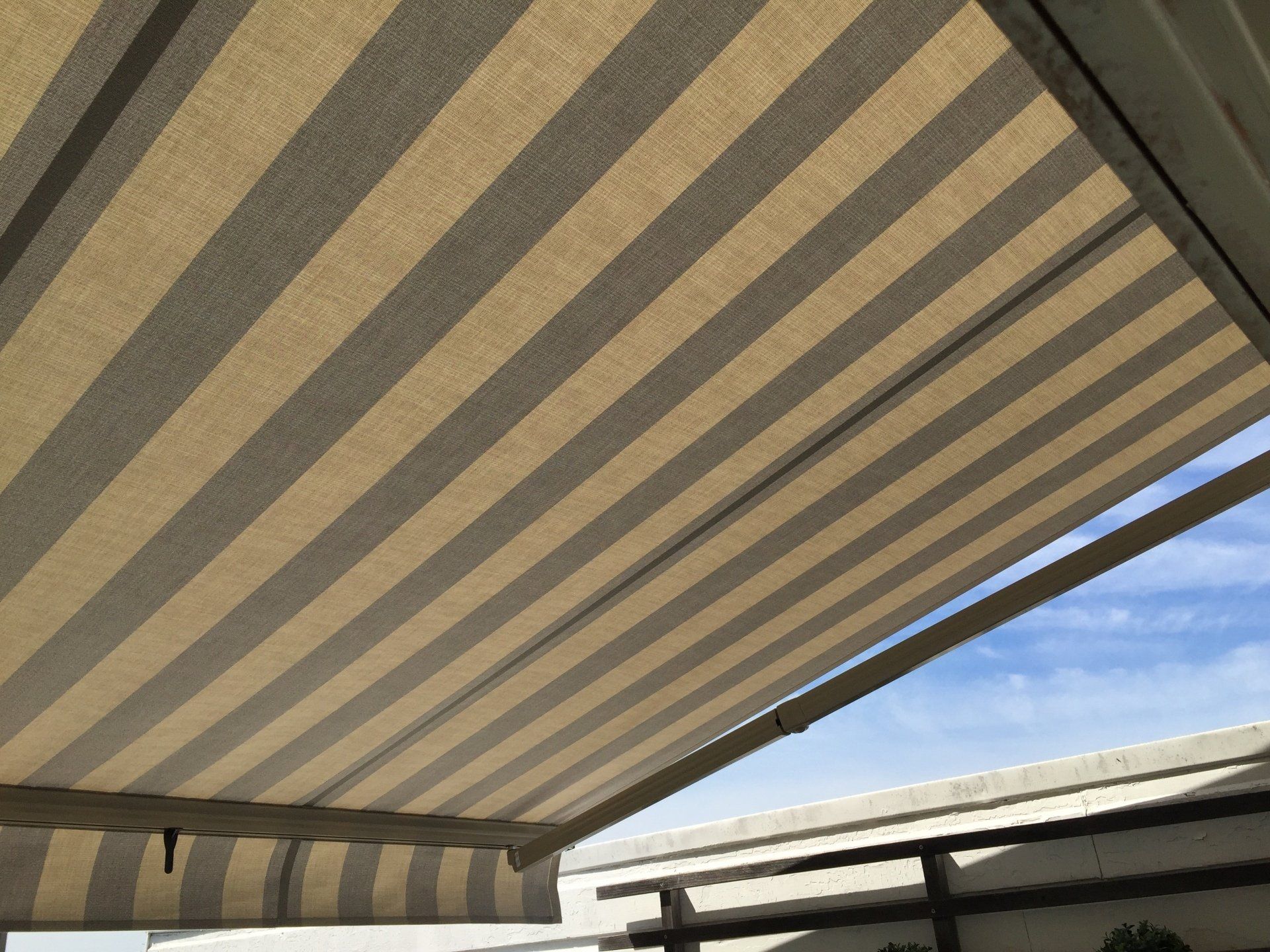A striped awning with a blue sky in the background