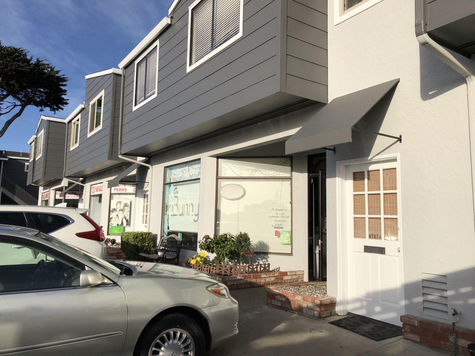 A white building with a car parked in front of it