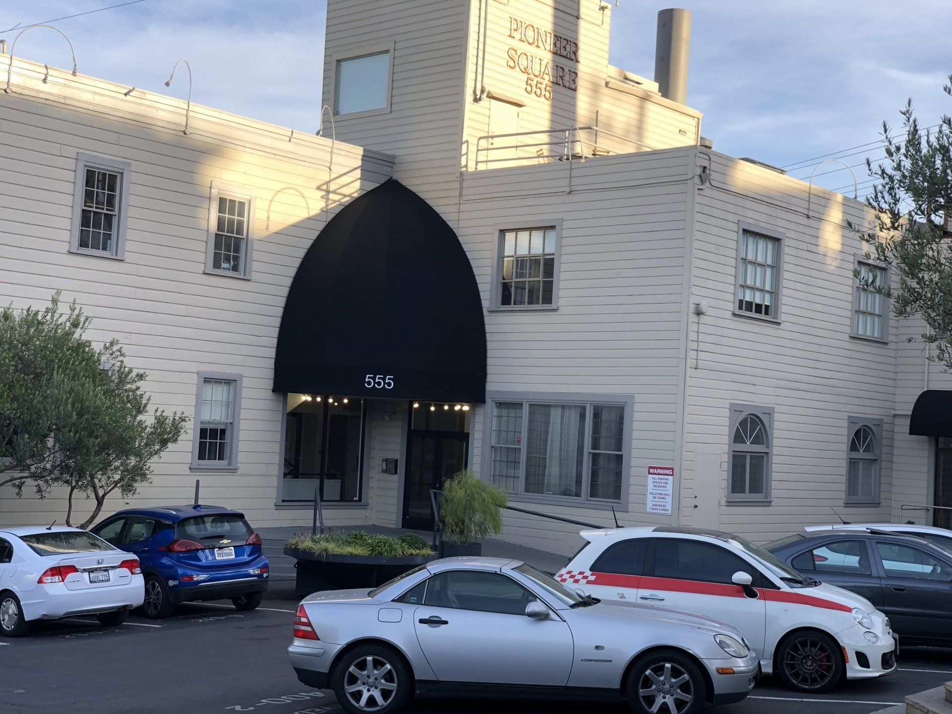 A white building with cars parked in front of it