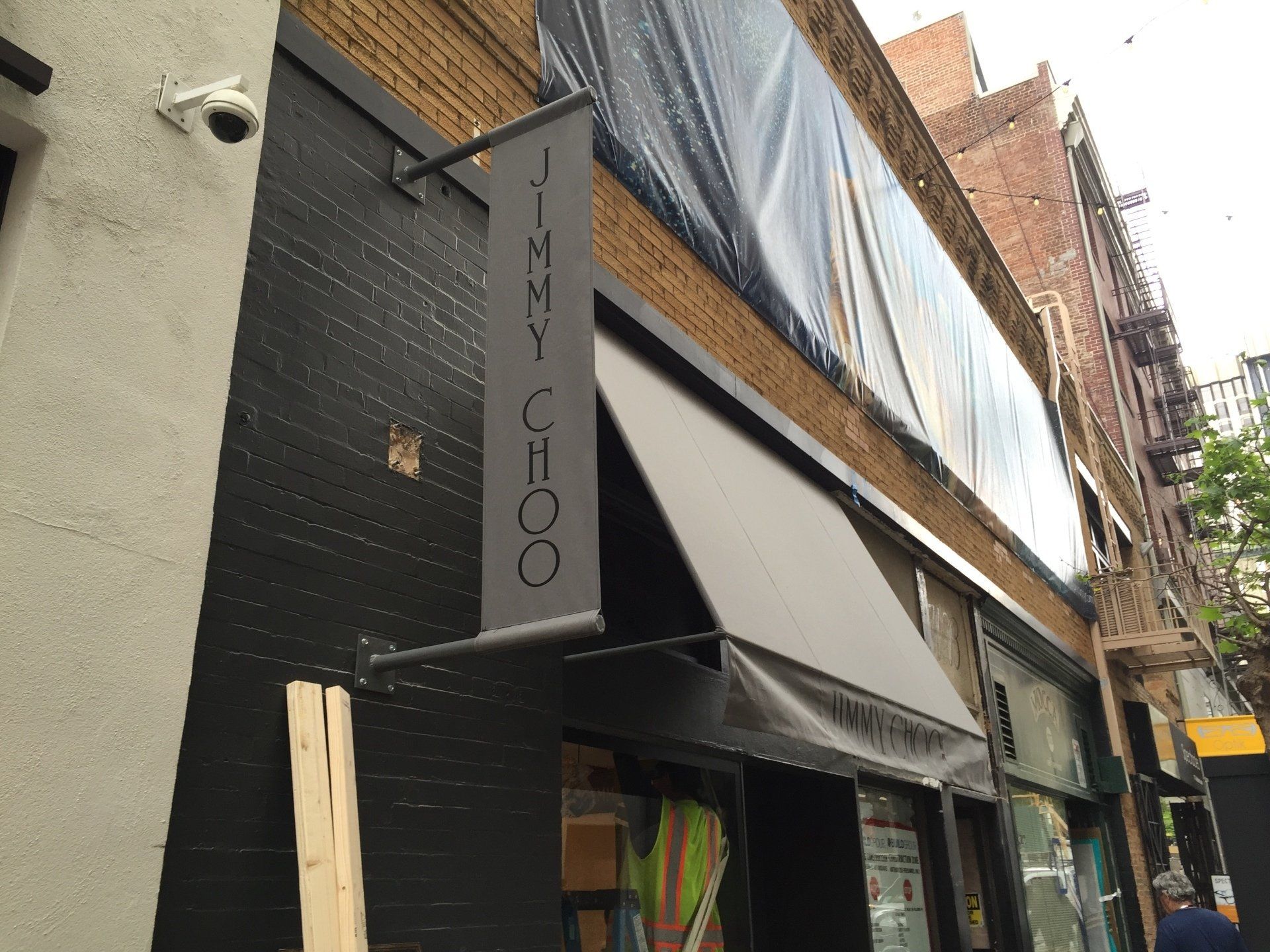 A jimmy choo store front with a black awning