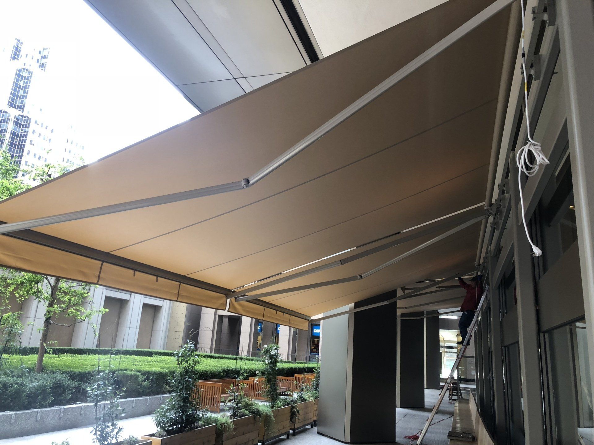 A large awning is being installed on the side of a building.