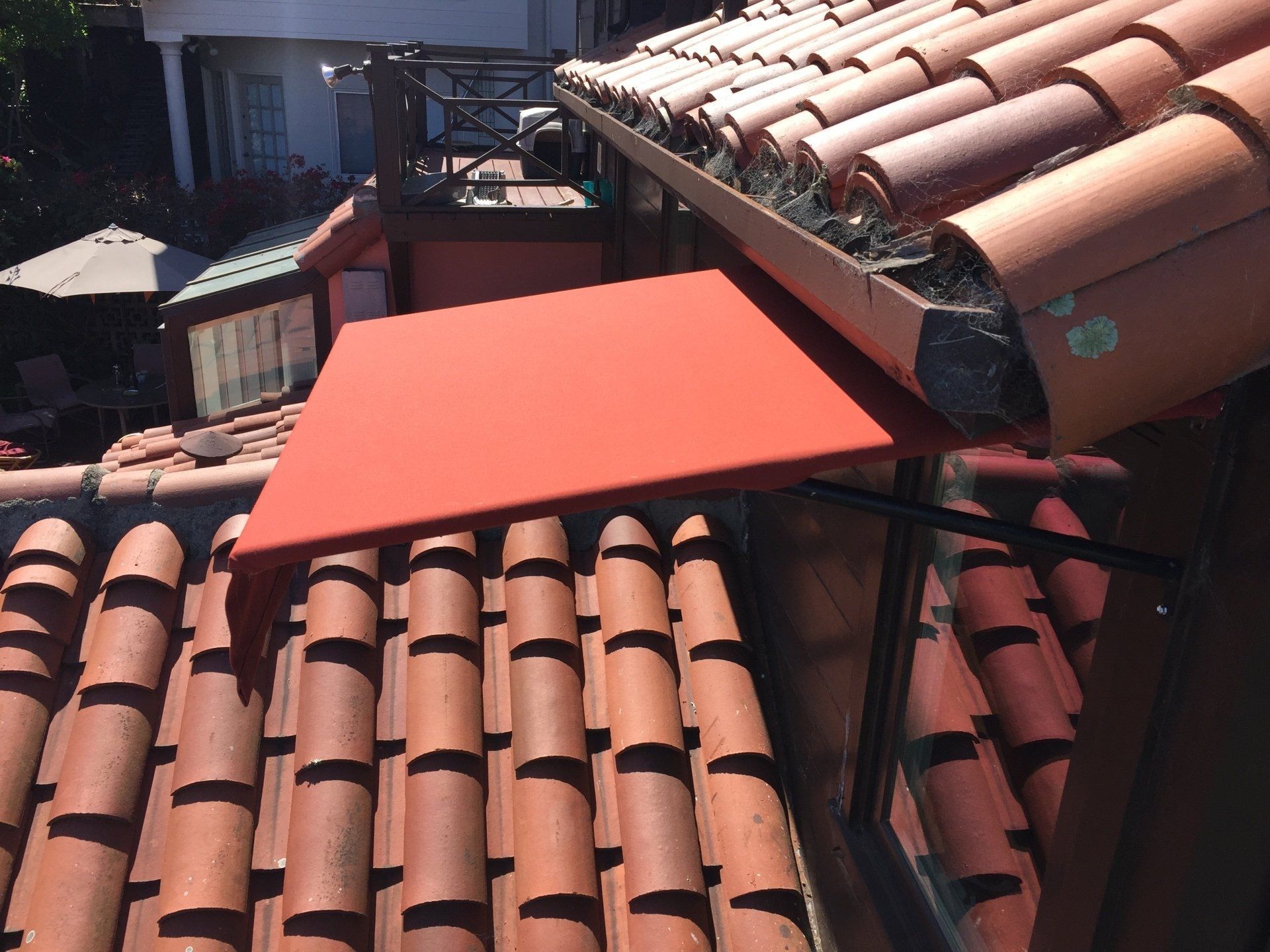 A roof with red tiles and a red triangle on top