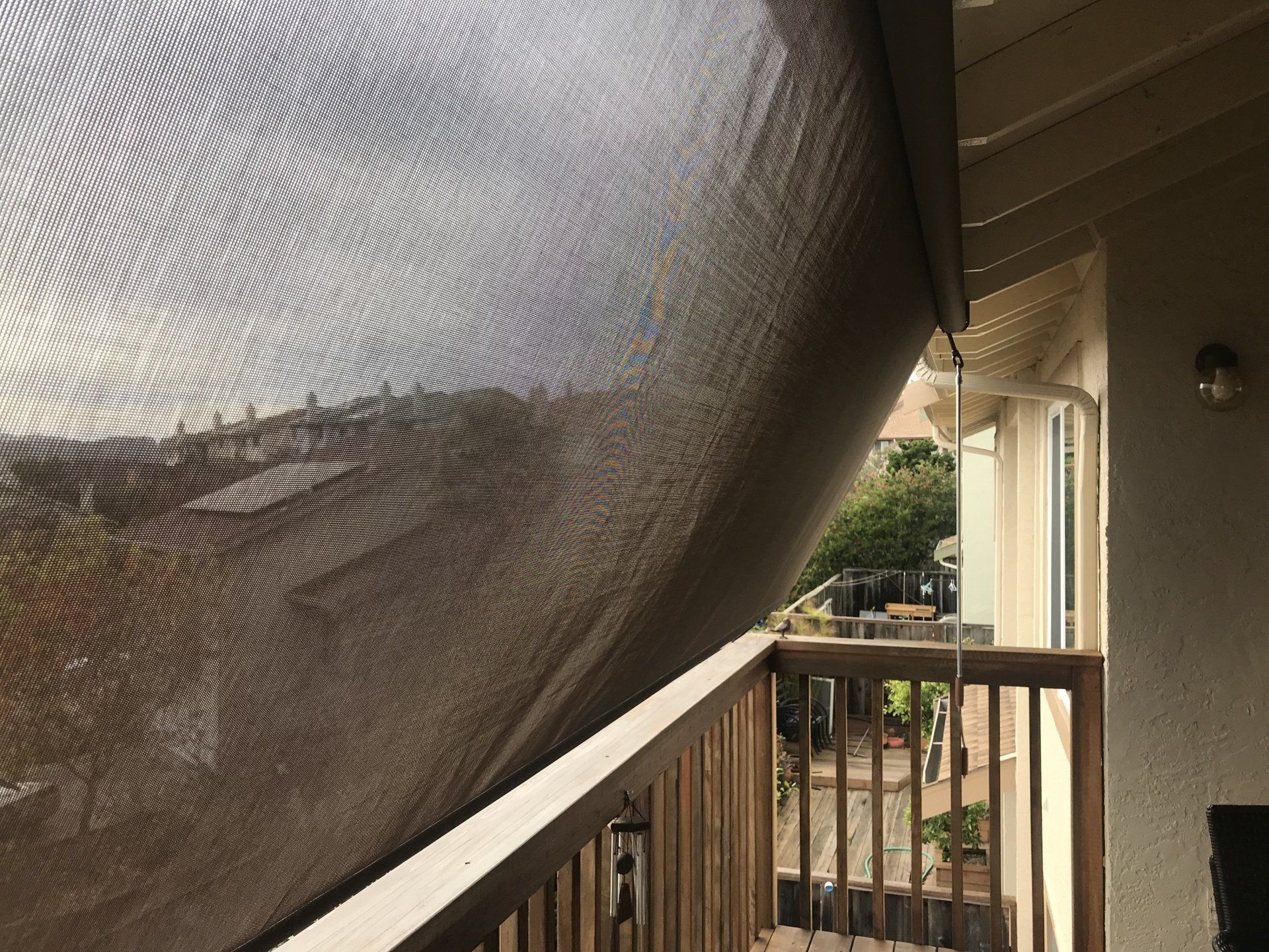 A balcony with a screen on it and a view of the mountains.
