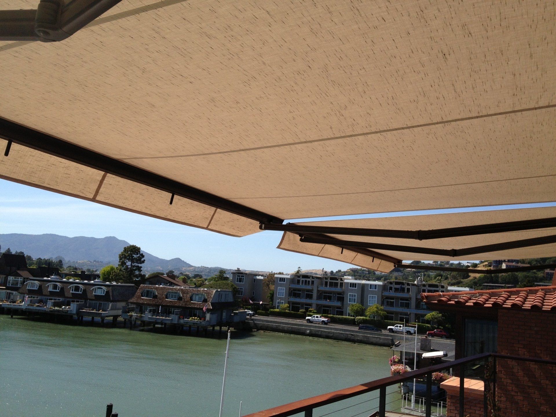 A balcony with an awning overlooking a body of water