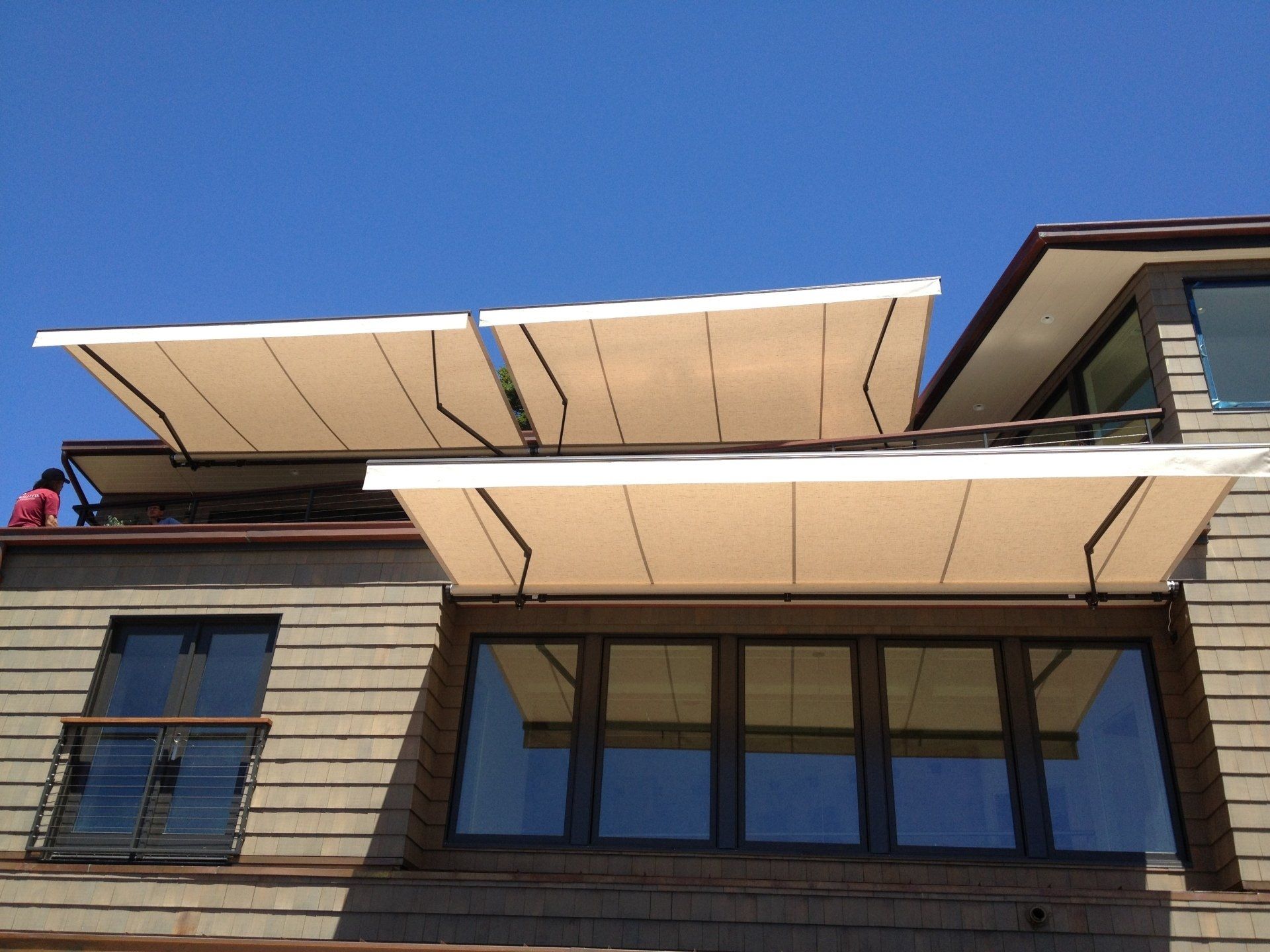 A house with a balcony and awnings on the roof
